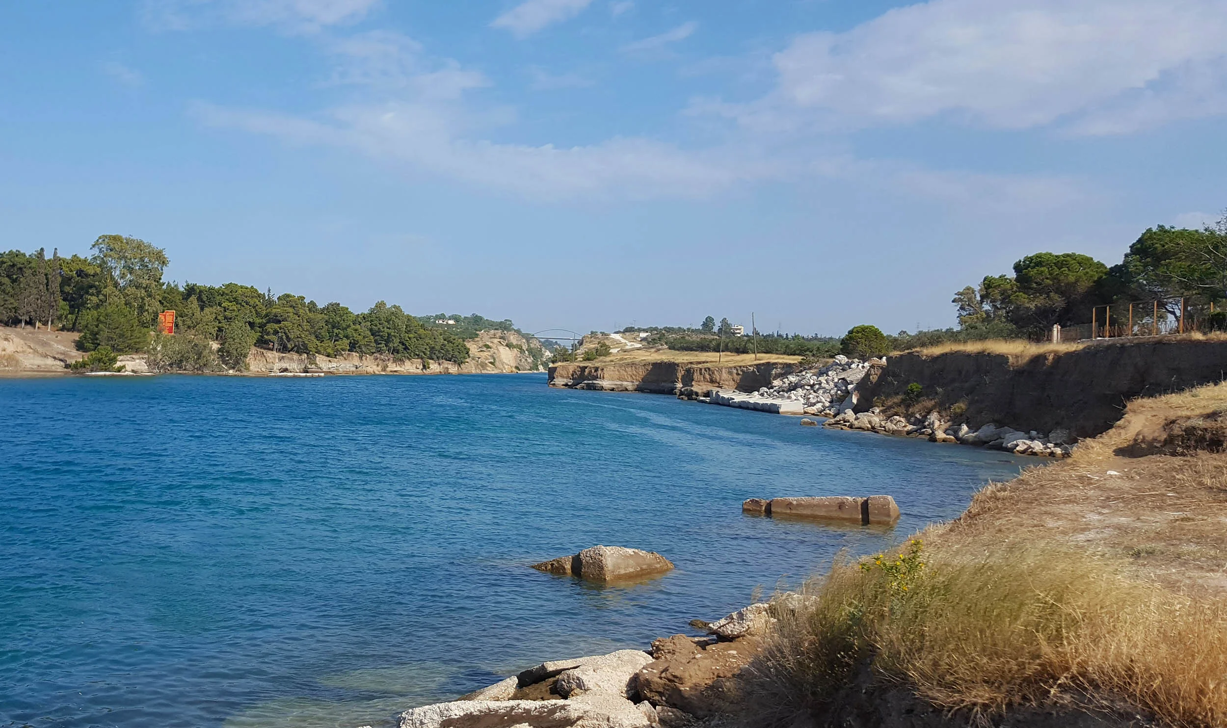 Corinth canal bridge and diolkos enters water.jpg