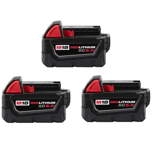 Three Milwaukee M18 18 Volt 5.0 Ah Lithium Ion XC Extended Capacity Battery Packs arranged on a flat surface