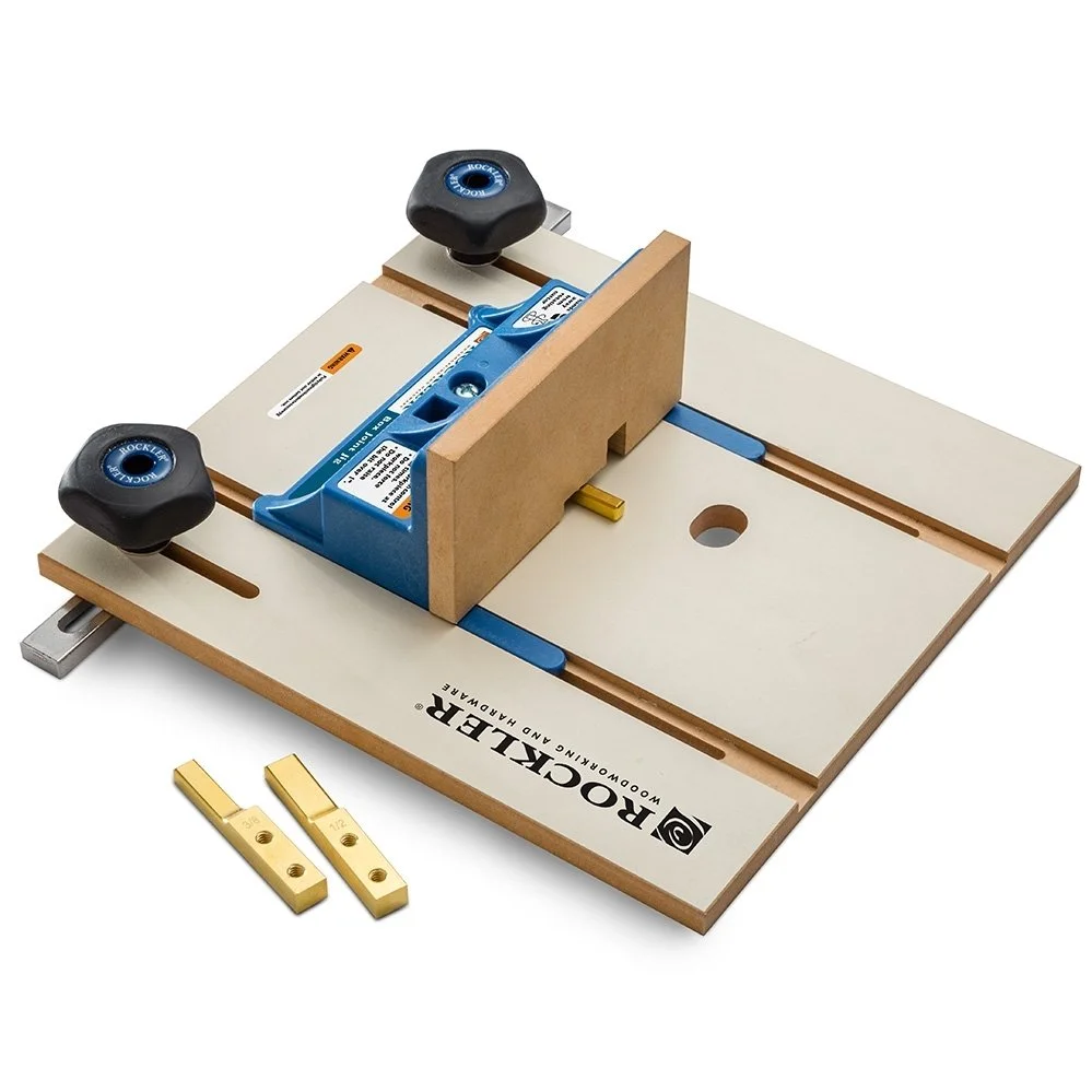 Rockler router table box joint jig with blue knobs and brass indexing keys on a router table surface