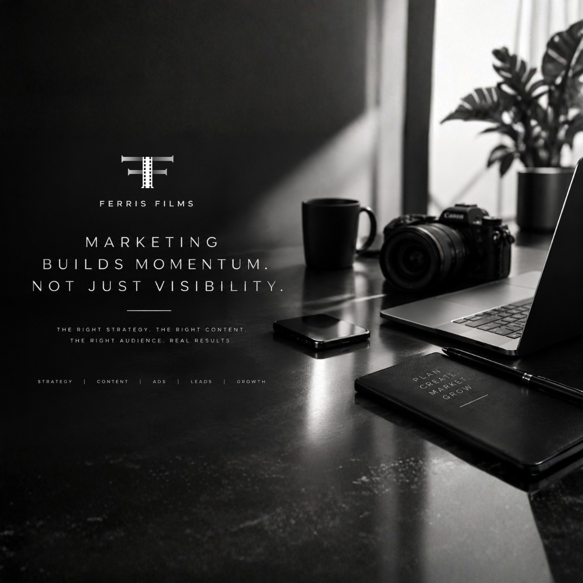 Black and white photo of a workspace with a camera, smartphone, laptop, notebook, pen, and coffee mug on a desk.