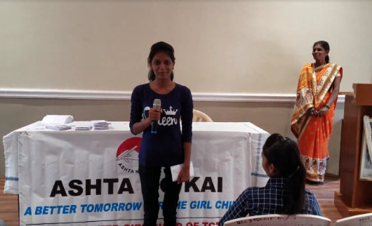 Image: Student giving a speech at an Ashta No Kai scholarship award ceremony with mother looking on. Photo credit: Maxine Cleminson, 2019.