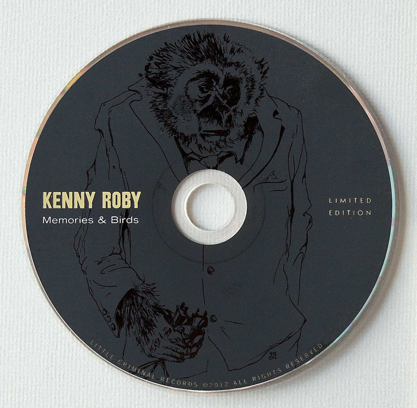 CD. Matte black on top of opaque white flood with gloss black line drawing.