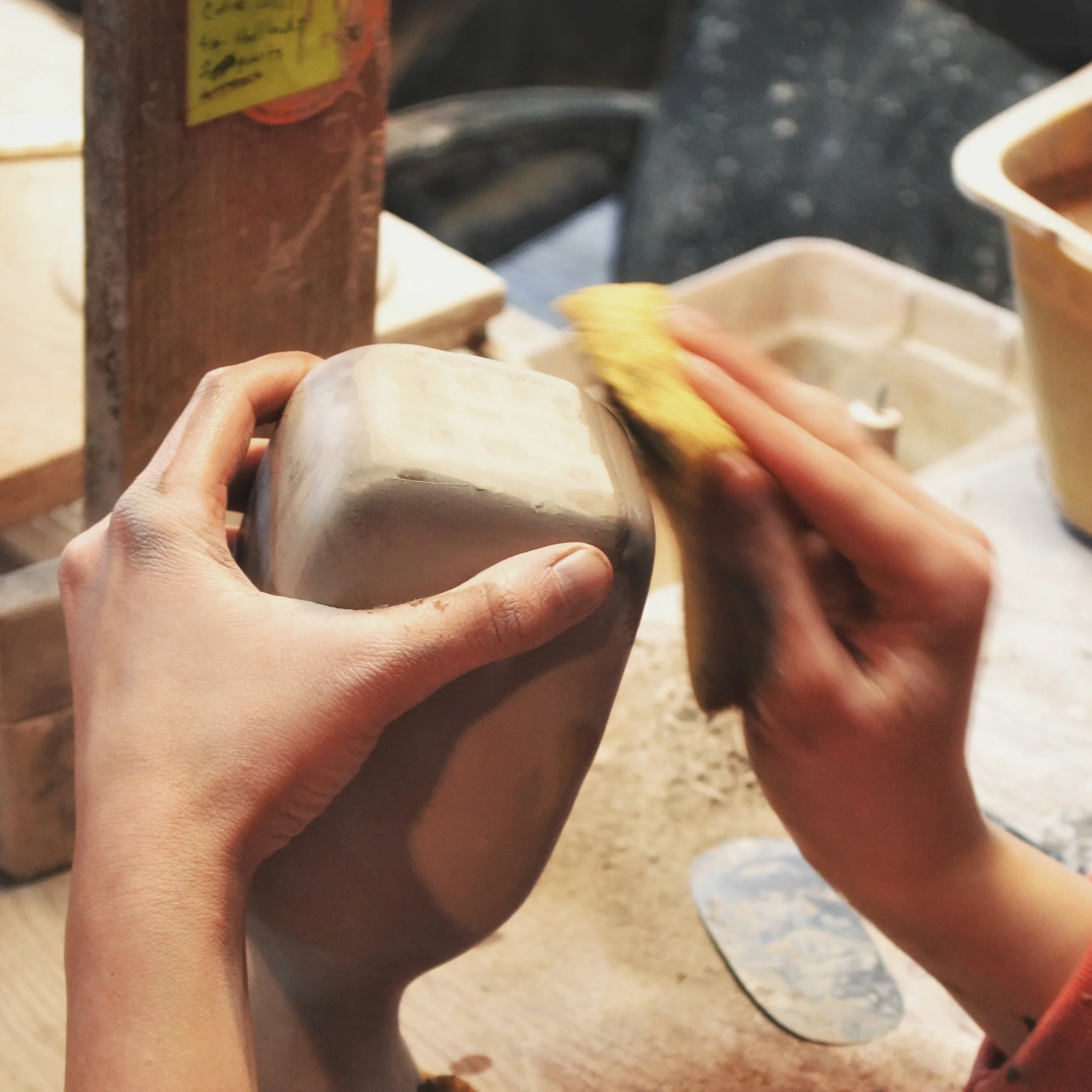 Once dry, this fragile greenware undergoes extensive hand finishing, to smooth the surface, round the edges, shape final details, and prepare it for glazing and firing.
