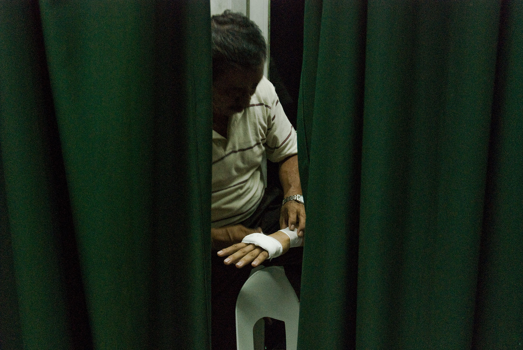 Behind the curtains, trainer wrapping boxer’s hand before a fight.