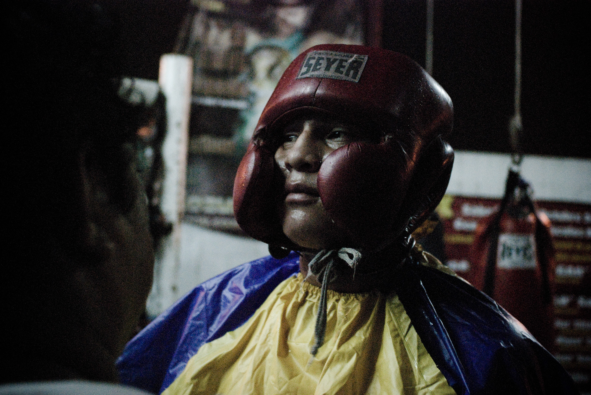 Boxer glances at his sparring partner before entering the ring at Lopez’s boxing gym.