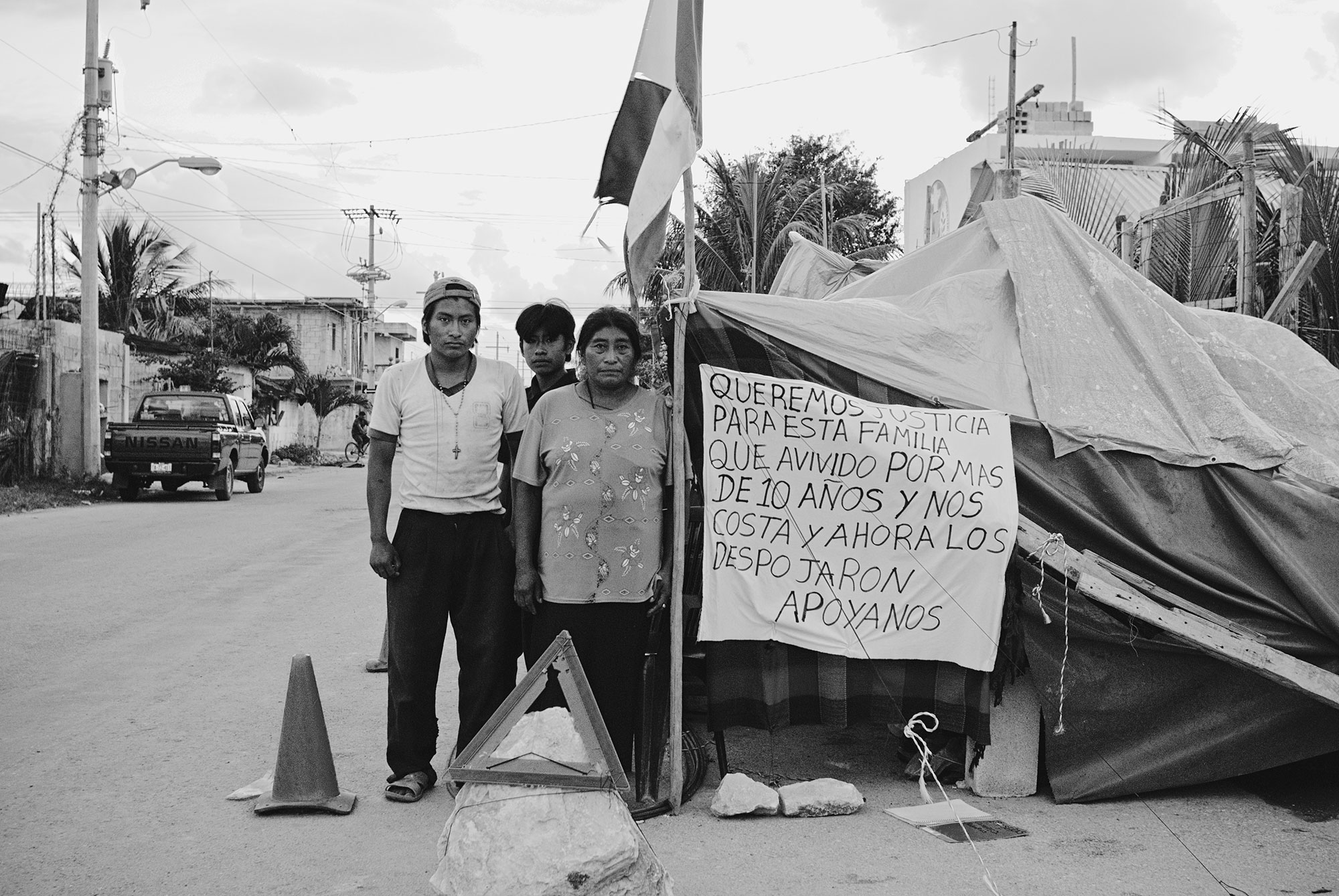 A family protesting eviction from their home. The touristic outburst in Playa Del Carmen caused the expansion of the city. Many families were evicted from their homes in order to build new luxurious condominiums to accommodate tourists.