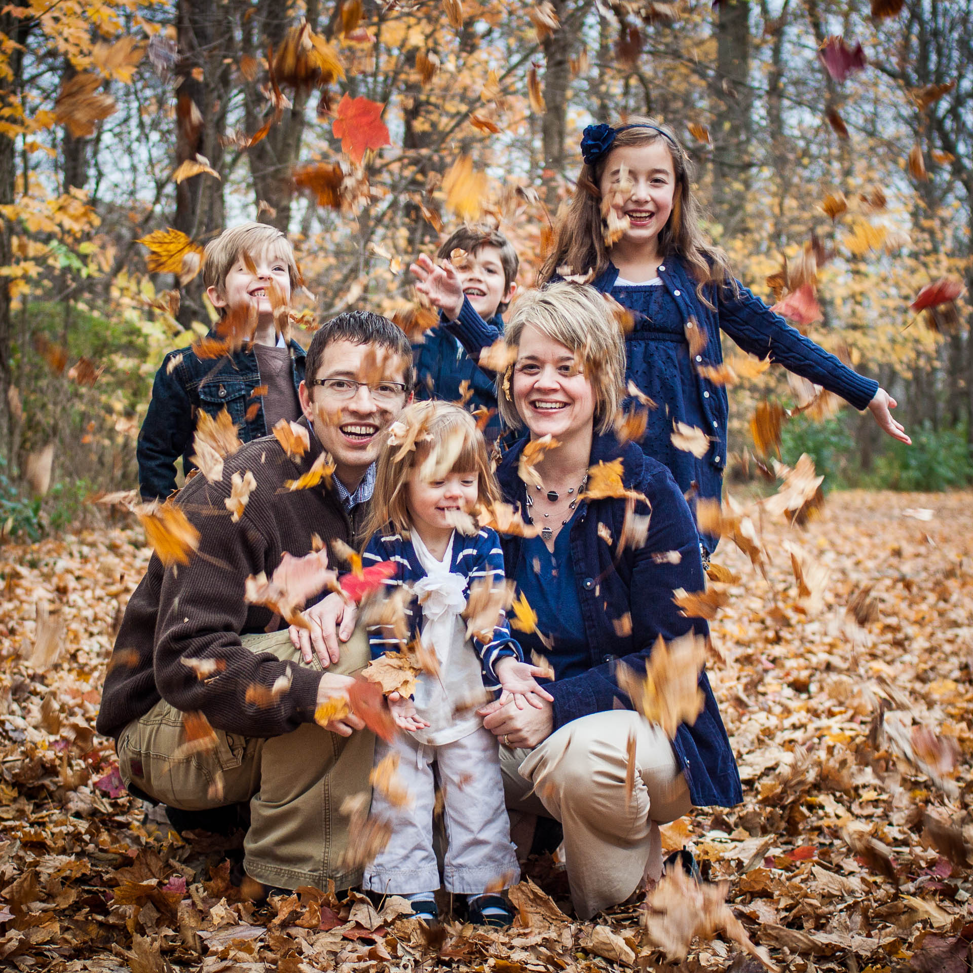 fun family photos playing in the leaves outdoors