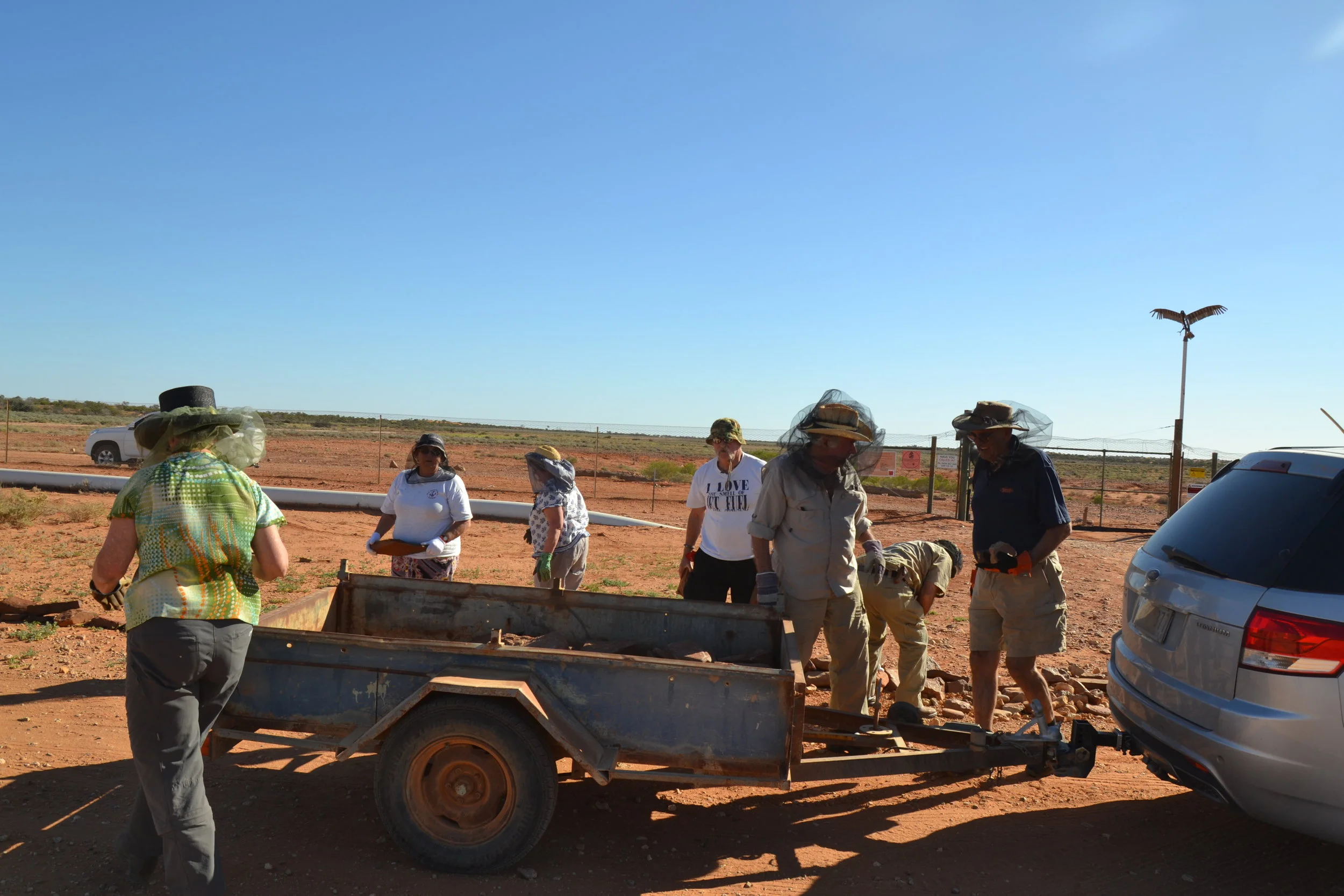 At the entry security gate the road side stones were removed and placed in the water run off area inside the compound. This allowed the tour buses easier access. The 2 trailer loads of rocks and many hands made light work of this.