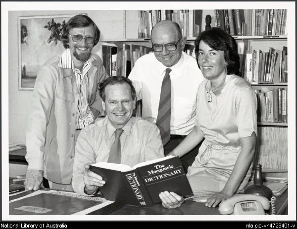 David Blair, Arthur Delbridge (seated), John Bernard, Sue Butler with the first edition of the Macquarie Dictionary