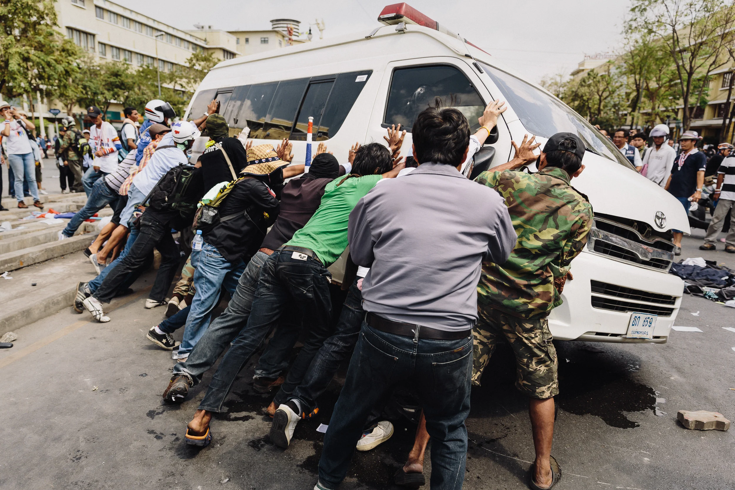 Anti-government protesters overturn an ambulance following clashes between demonstrators and police.