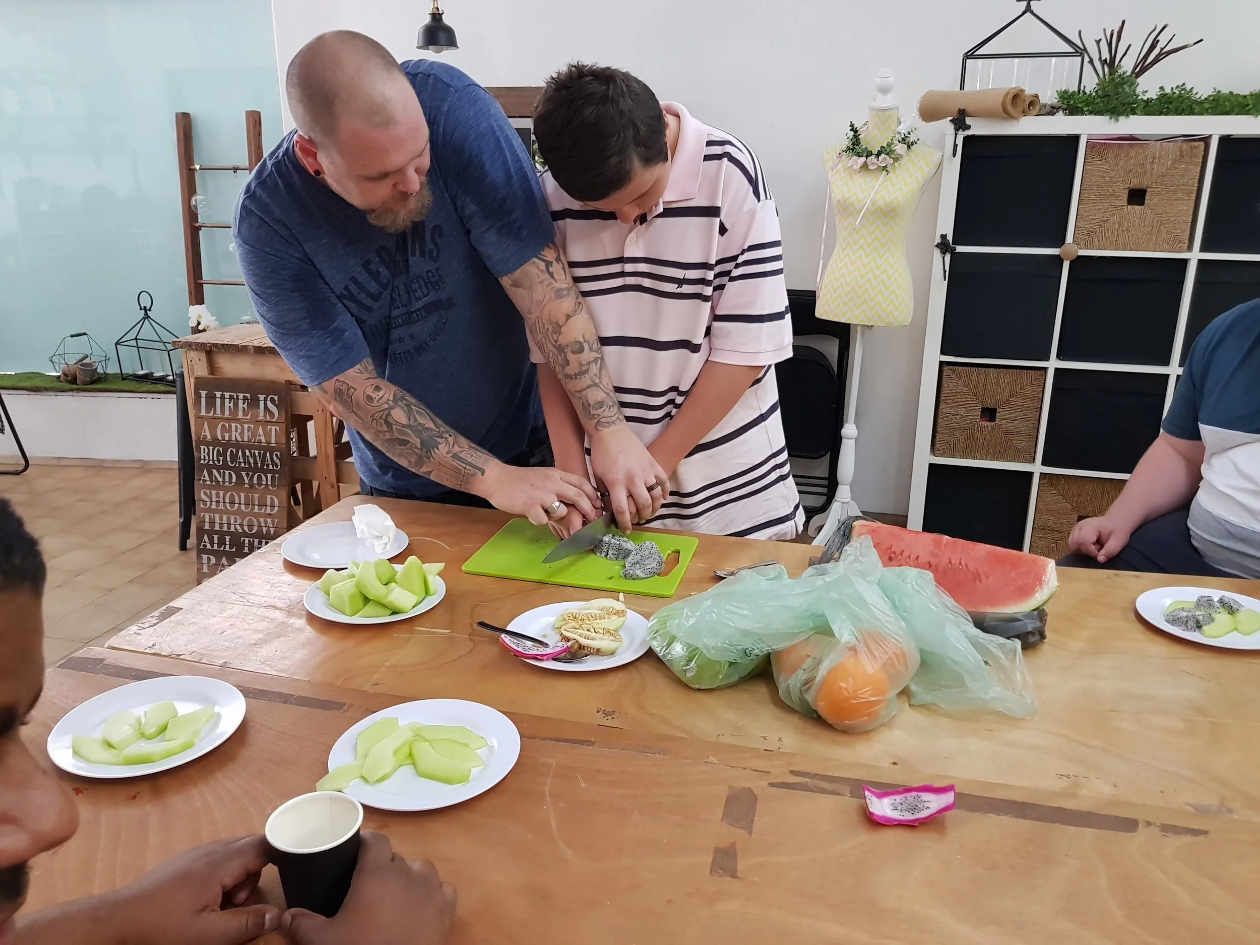 Adam helps one of our participants in a cookery course. Yes, the knives are sharp.