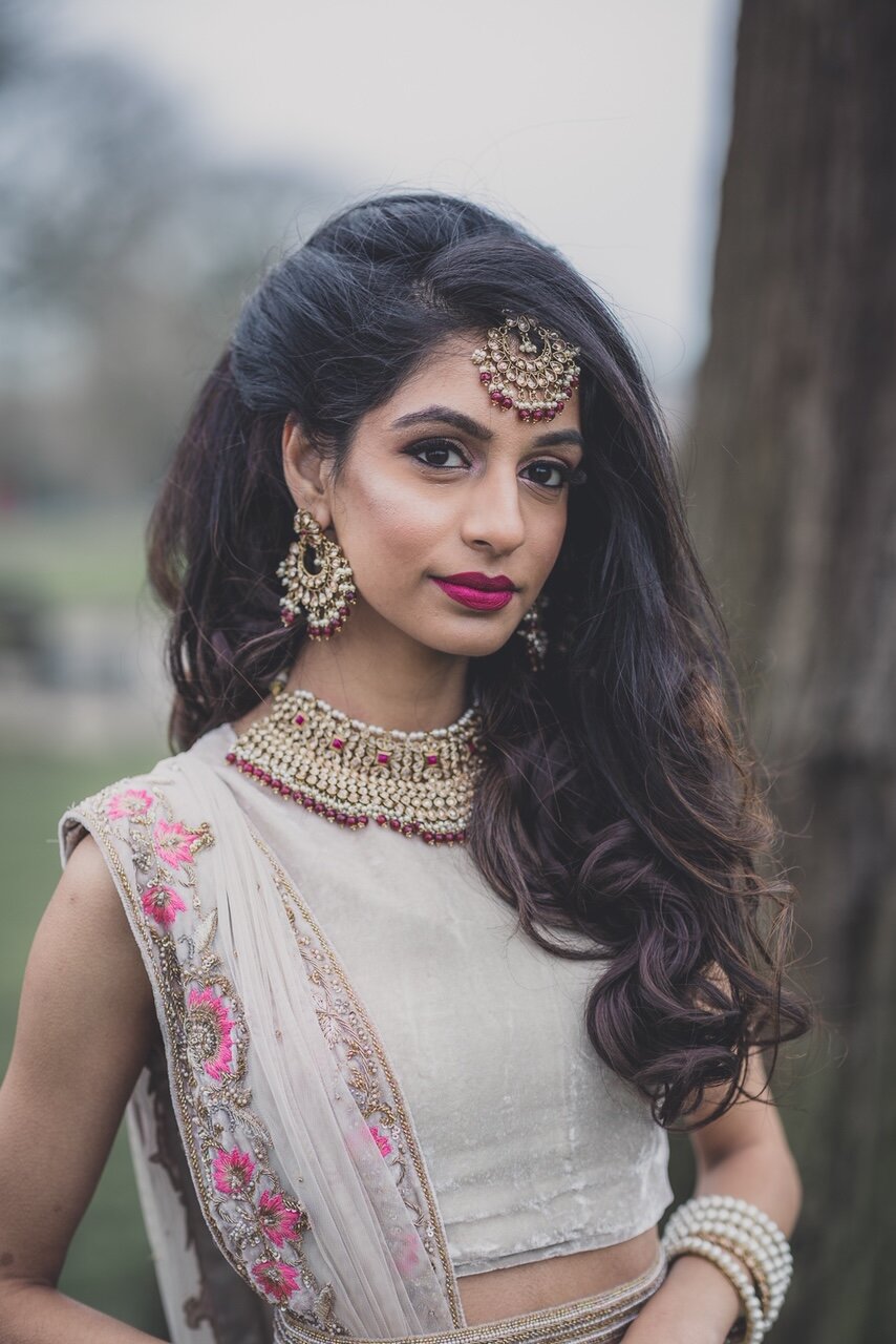 Winter bride in park with deep purple colours on her lips