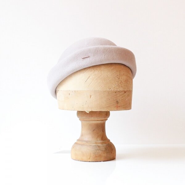 un petit chapeau béret en feutre de laine couleur gris beige