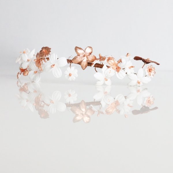une broche à chignon pour mariage romantique avec des fleurs en cuir blanc et cuivre