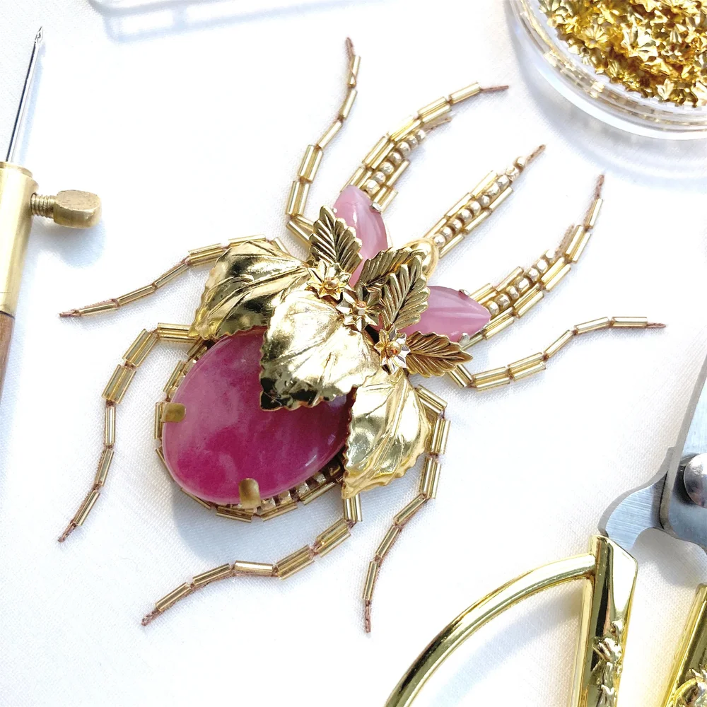 un insecte en pierre semi précieuse brodé avec du fil d'or