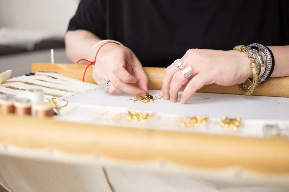 l'artisan atelier noboru en train de broder avec des pierres semi précieuse sur de l'organza de soie