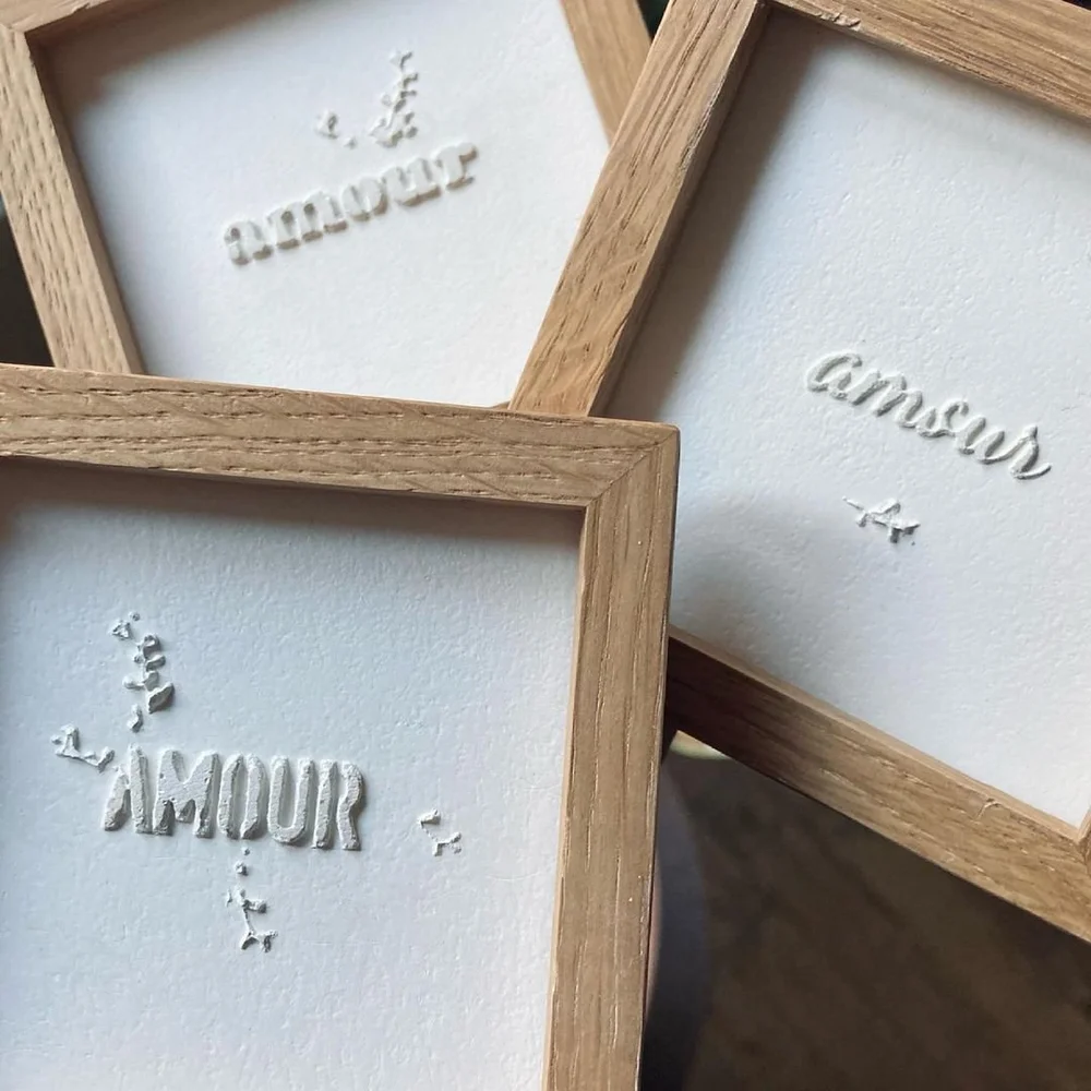 des petits tableaux encadrés en bois avec le mot amour dedans