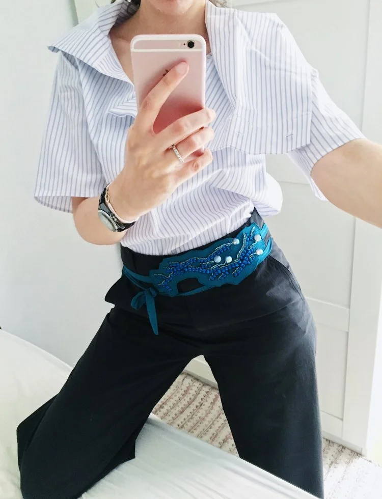 une ceinture bleue, brodée avec des perles de façon design, moderne et équilibrée