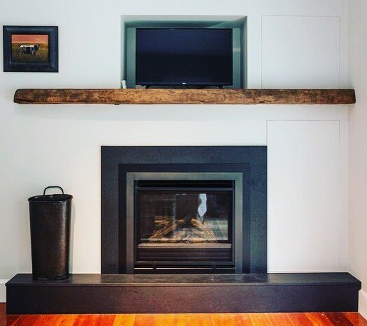 Rainy days call for cozy nights by the fire. #fireplace #mantle #custom #naturalwood #liveedgemantle #recessedtv #carpentry