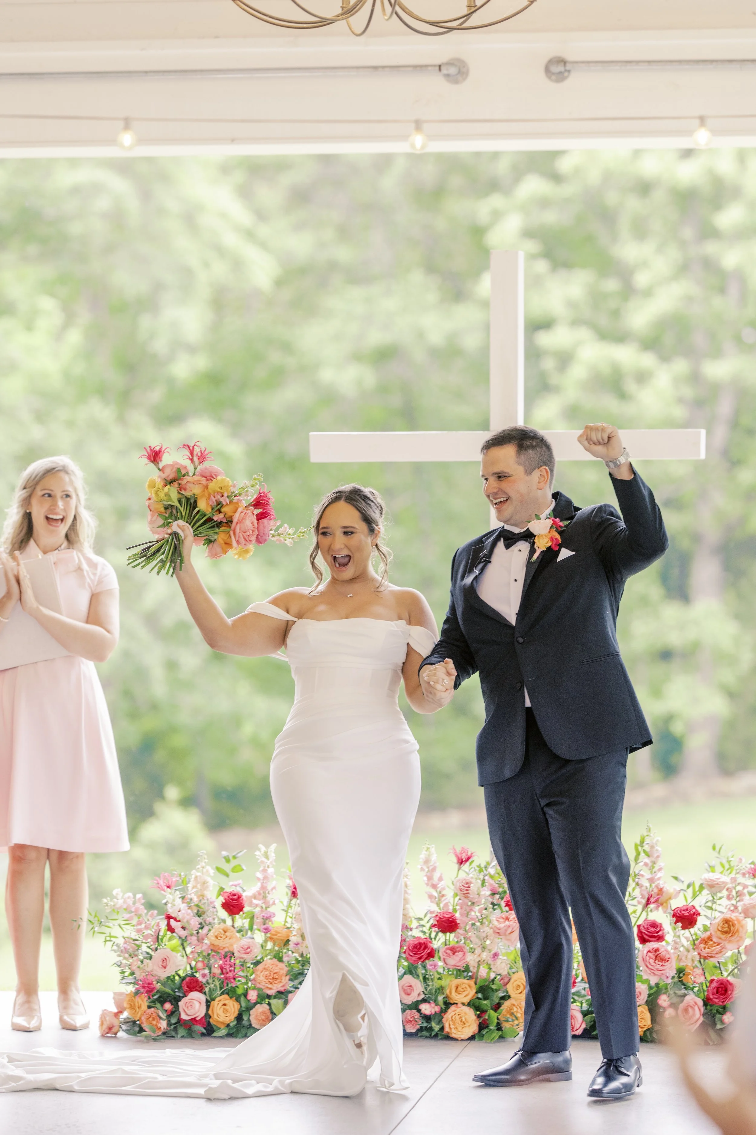 Wedding Ceremony Celebration a Bride and Groom in Charlotte NC in a black suit, white dress, with pink florals.