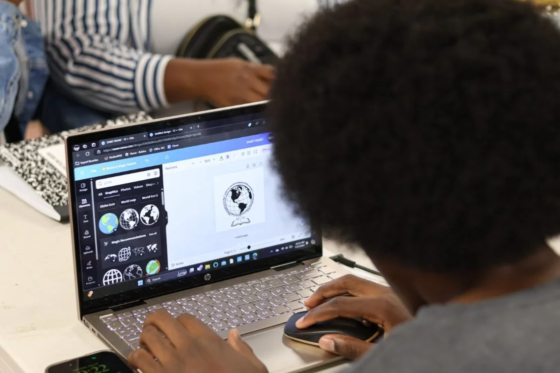 Person working on a laptop computer, designing a webpage with globe icons.