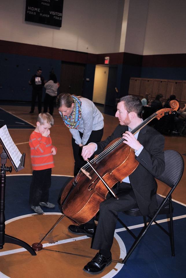 Matthew demonstrates his cello technique at an event with the Kansas State School for the Blind.