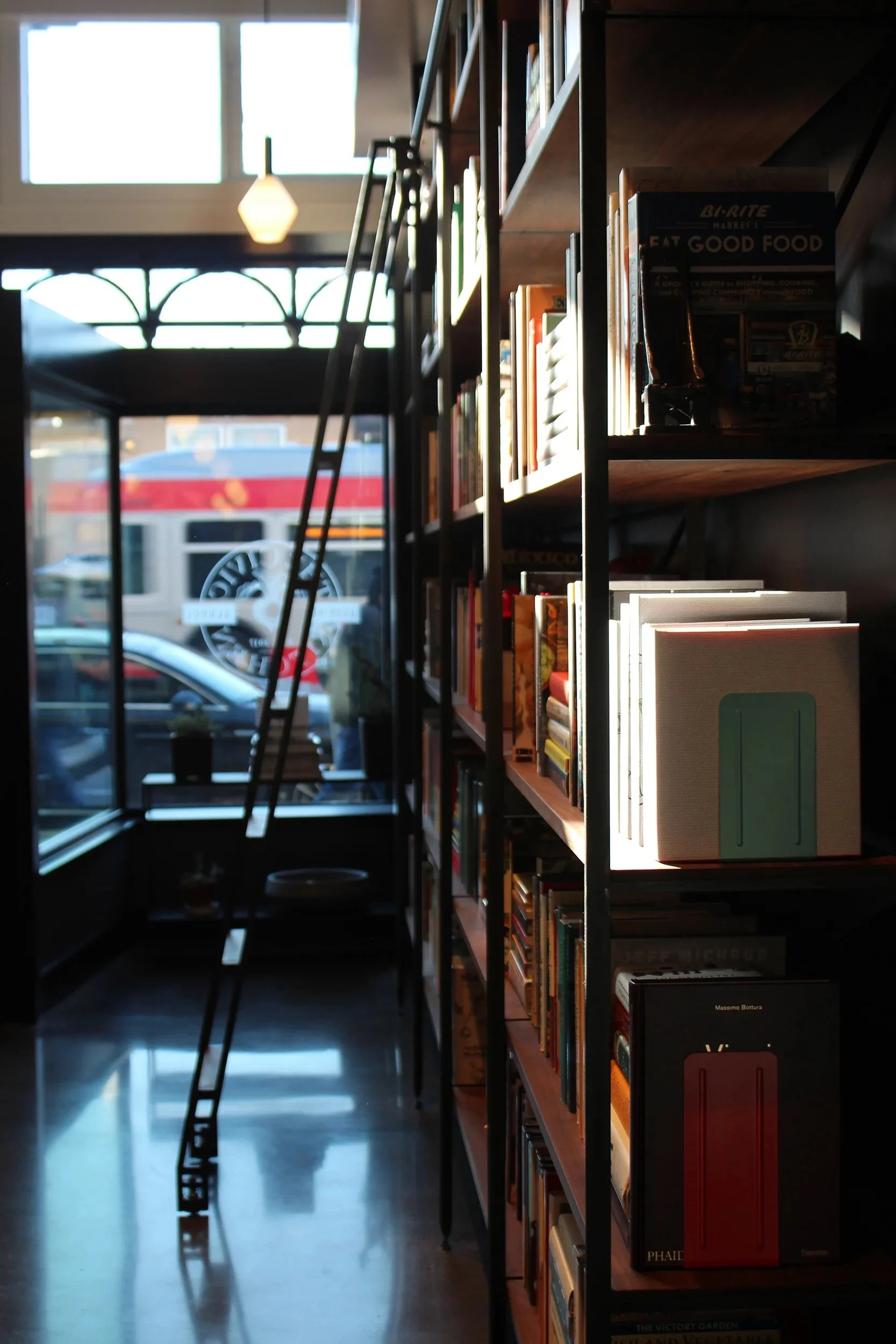  The custom Walnut and rolled blackened steel library wall holds an ever growing colorful cookbook collection. 