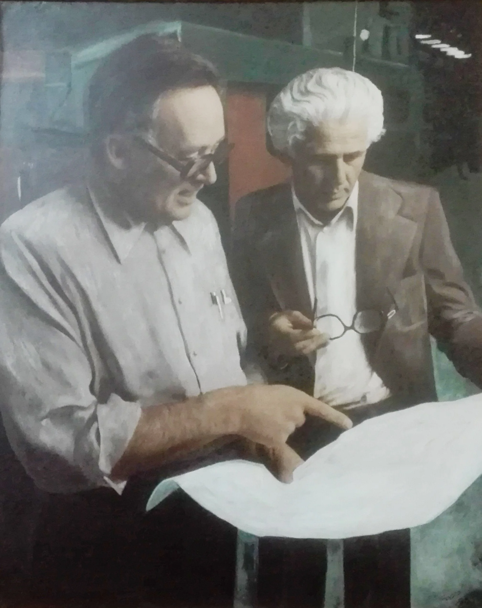 Dois homens, um com cabelo escuro e óculos, segurando uma caneta, e outro com cabelo branco e óculos na mão, olhando juntos para um documento ou planta em um escritório ou local de trabalho.