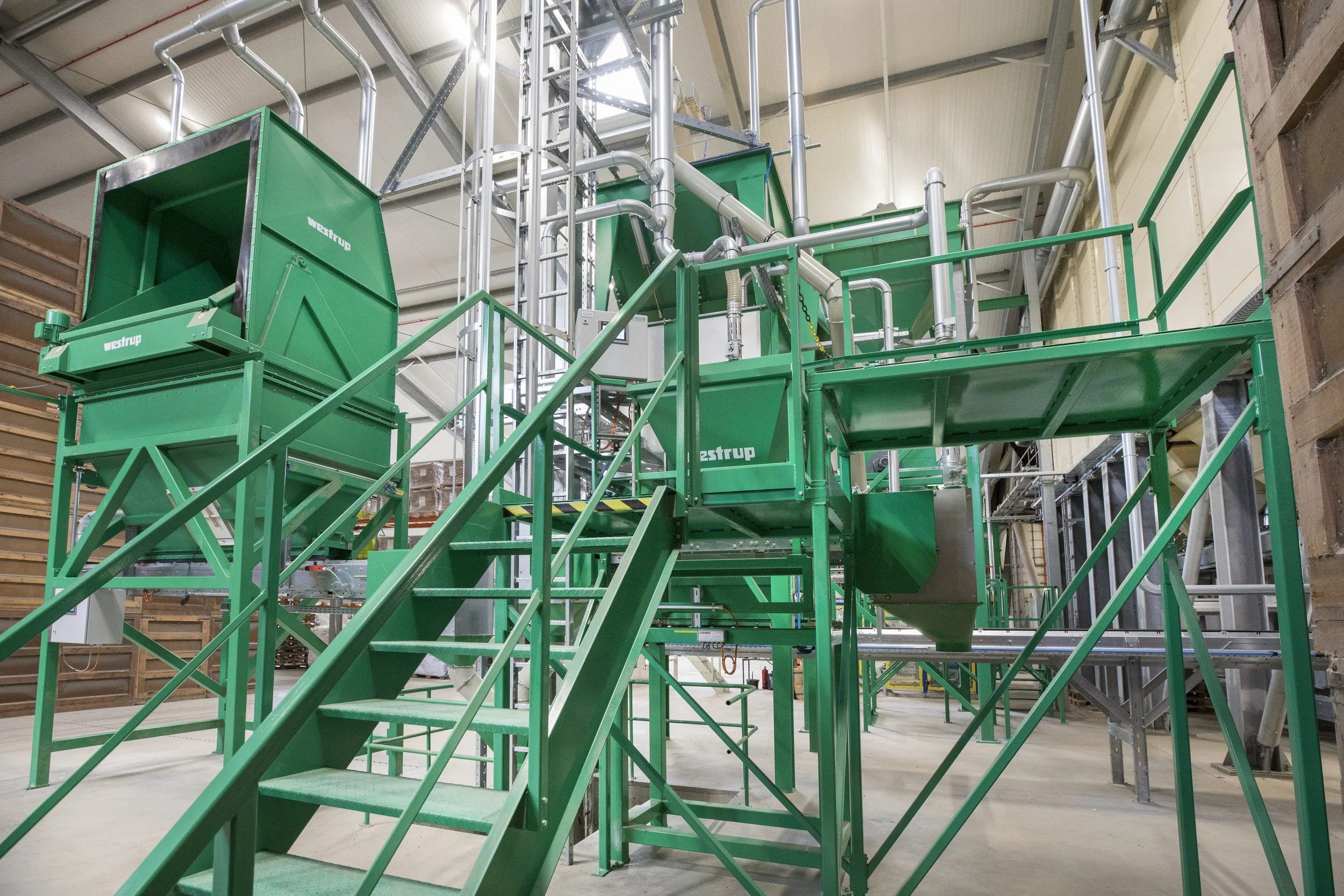 Industrial green machinery and equipment inside a warehouse or factory setting.