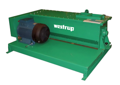 Green industrial machine with motor labeled 'Westtrup' on a metal base.