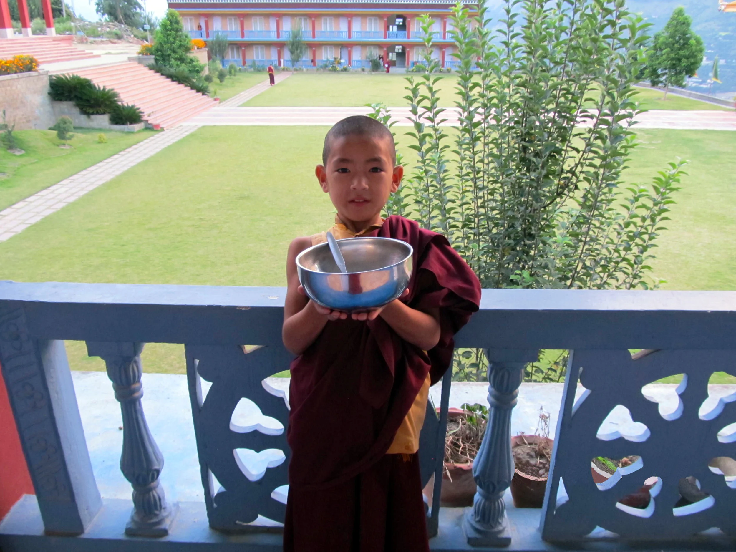 A young monk posted at the corridor of Dechen Choekhor monk’s hostels before heading for dinner with his alms bowl.