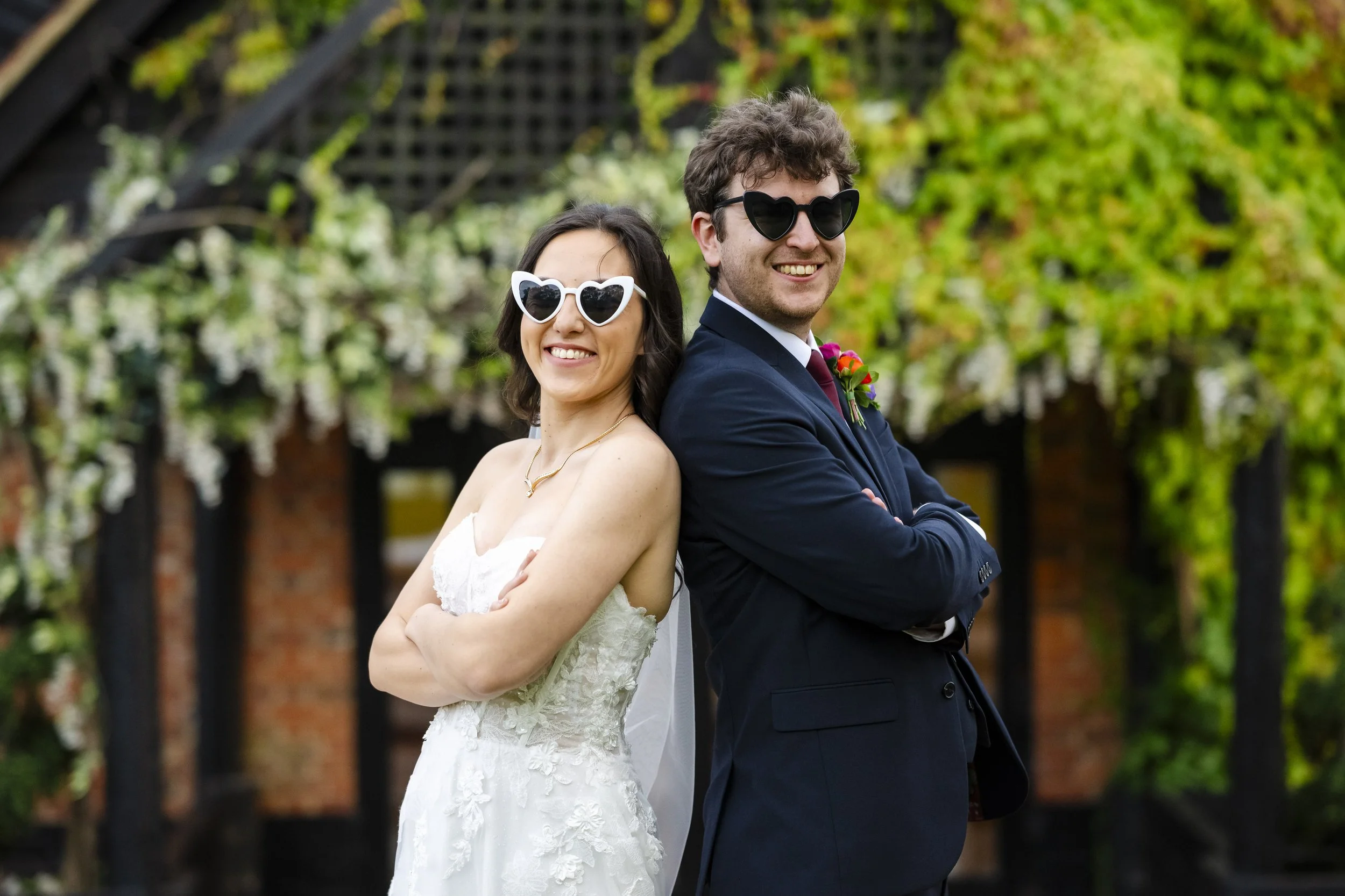A bride and groom back-to-back smiling at outdoor wedding.