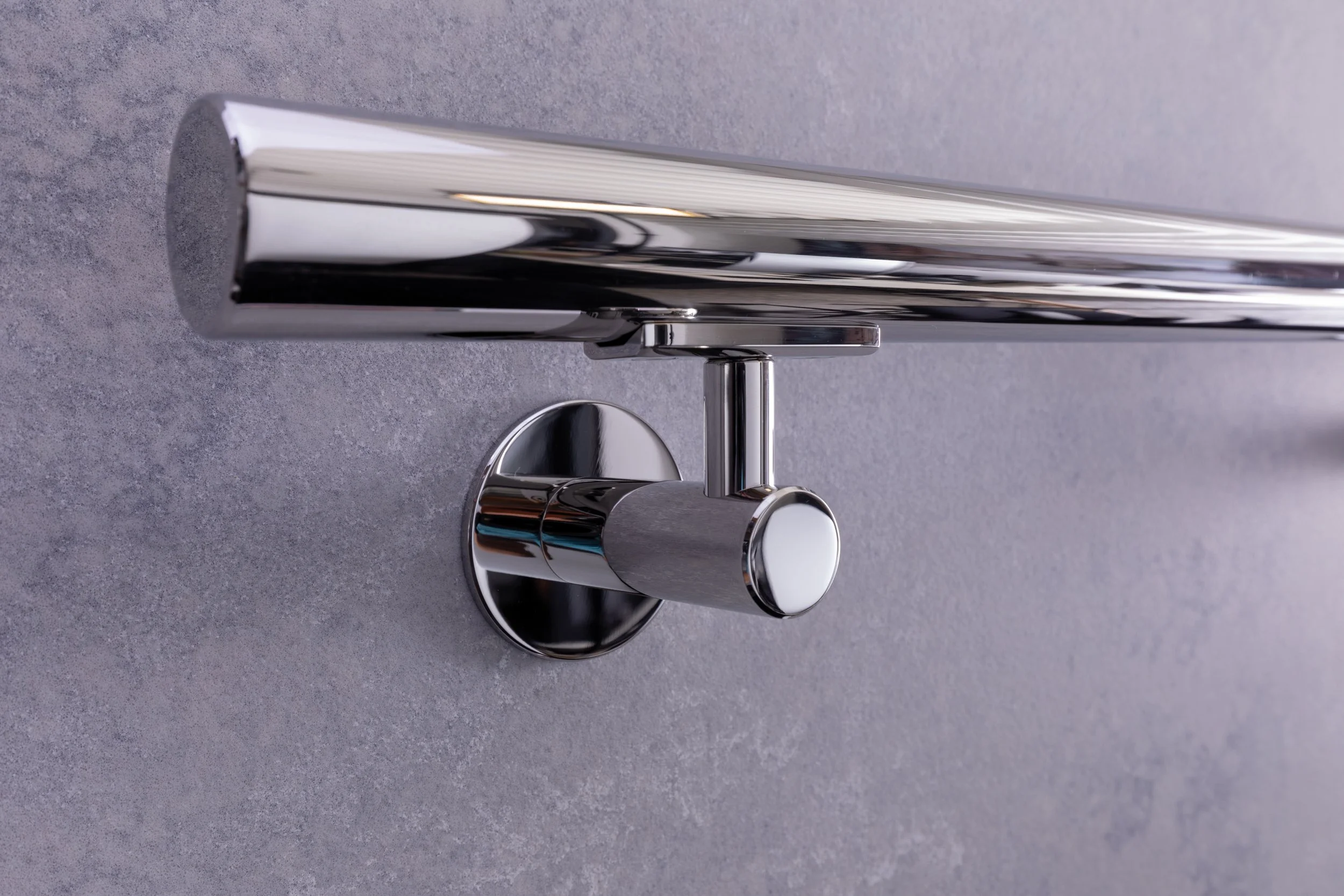 A shiny metallic faucet mounted on a grey countertop.