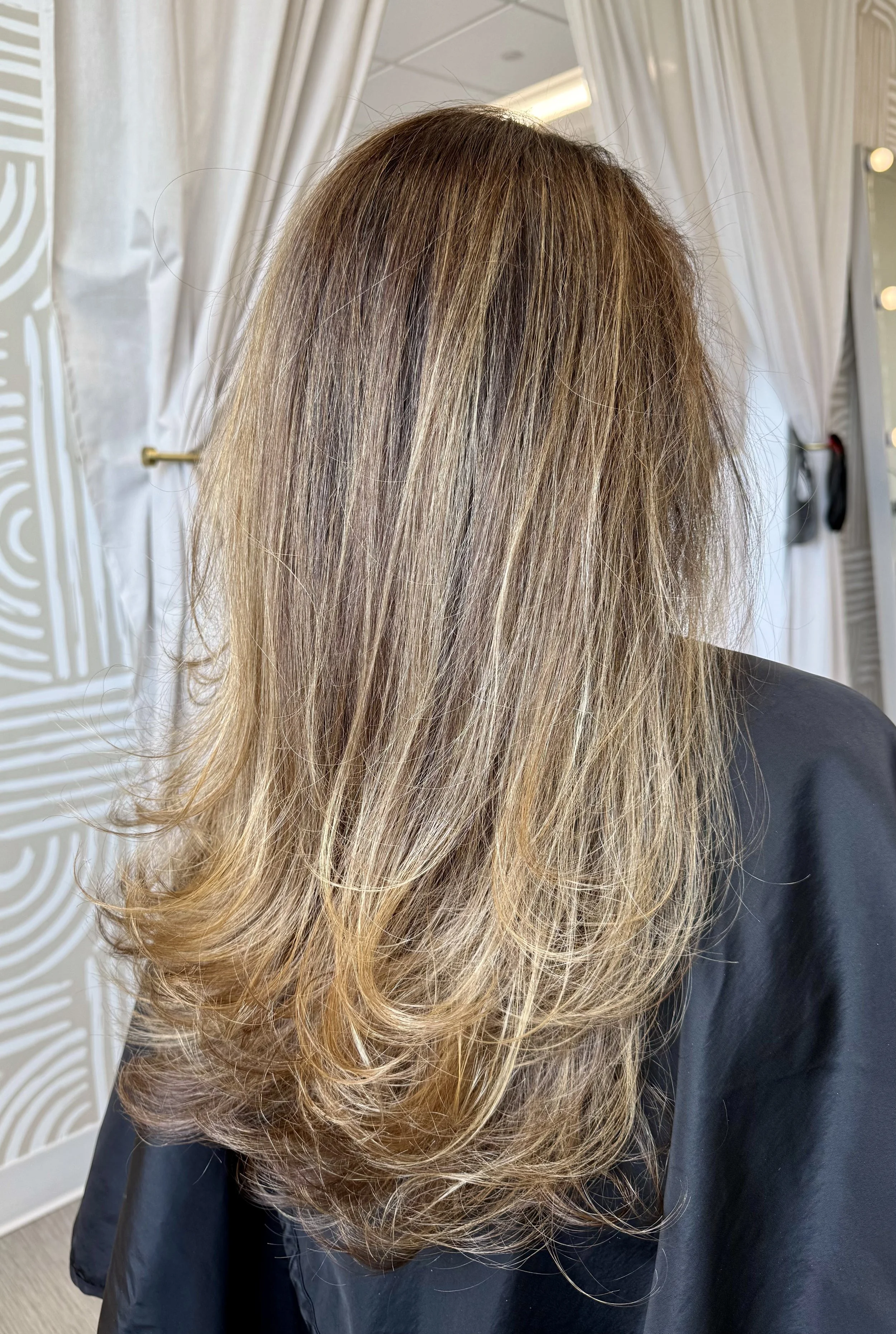 Subtle blonde highlights with a rooted blend for natural grow-out, maintaining soft contrast and long-term tone balance without frequent maintenance.