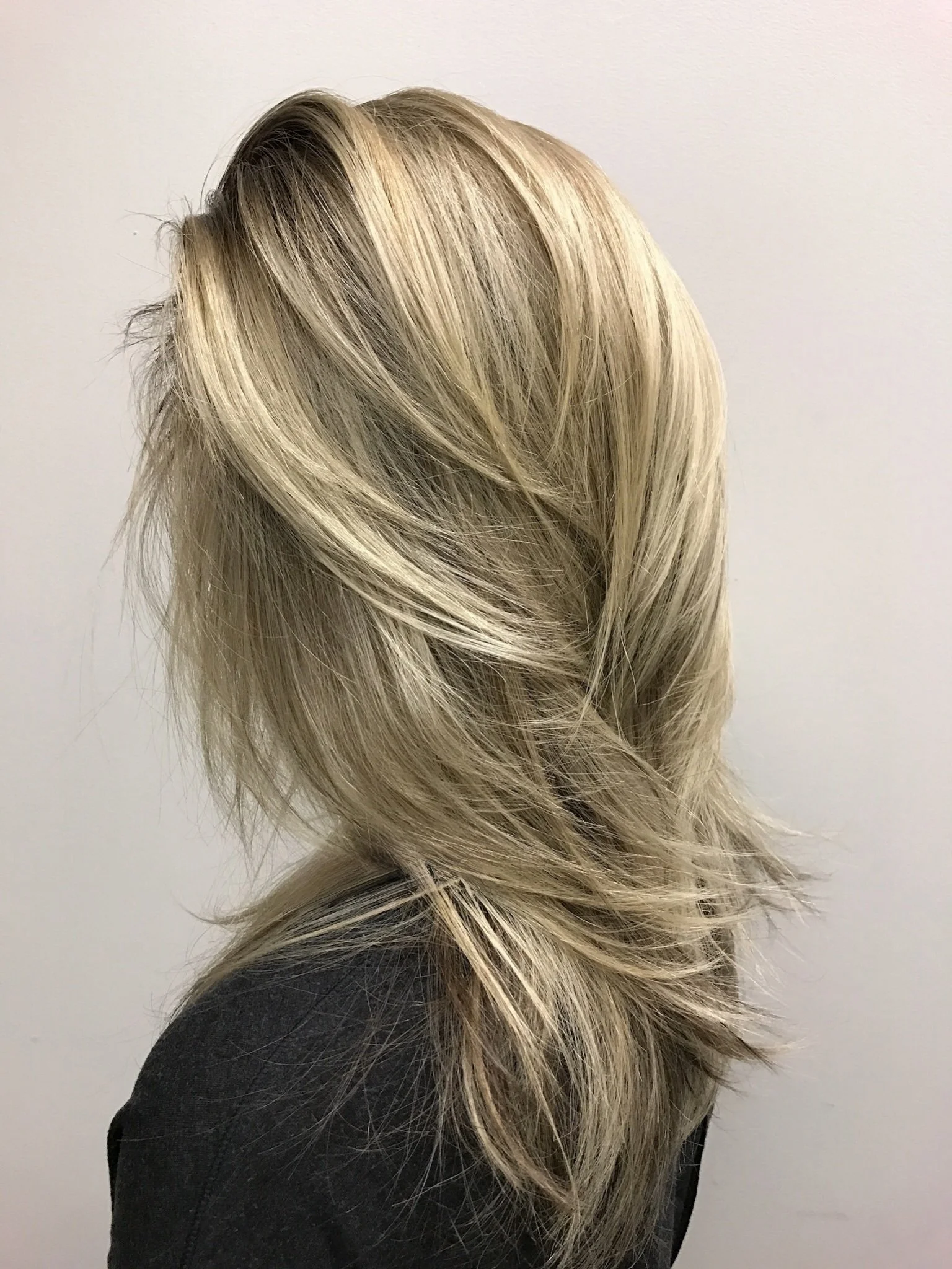 Blonde highlights with soft layered haircut for natural dimension and sculpted shape in Dallas, Texas.