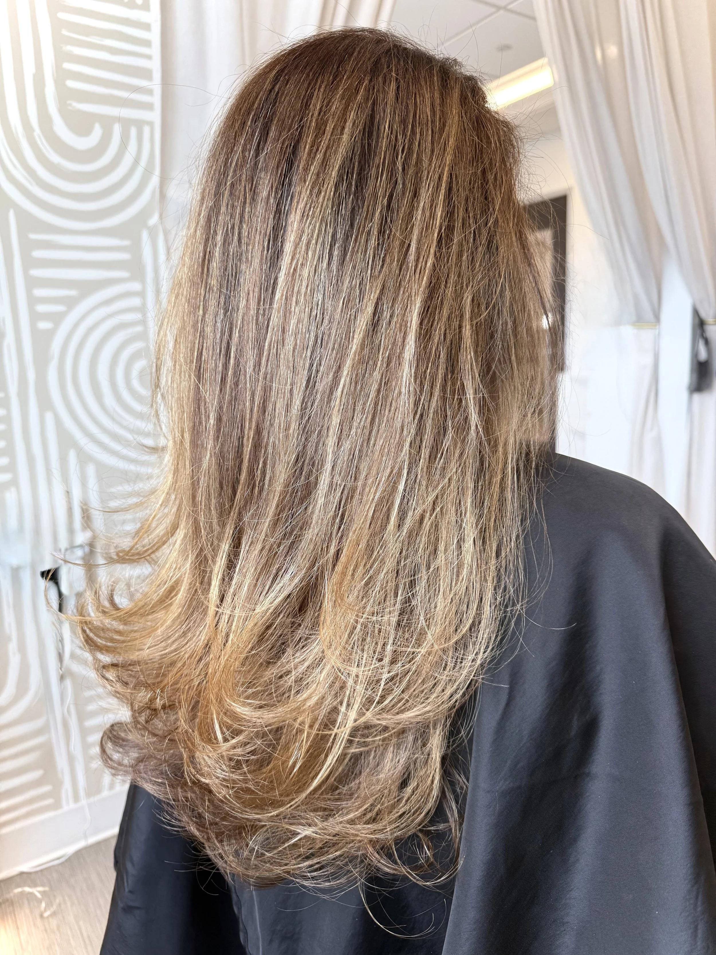 Precision blonde layered haircut with seamless fall and natural distribution of weight