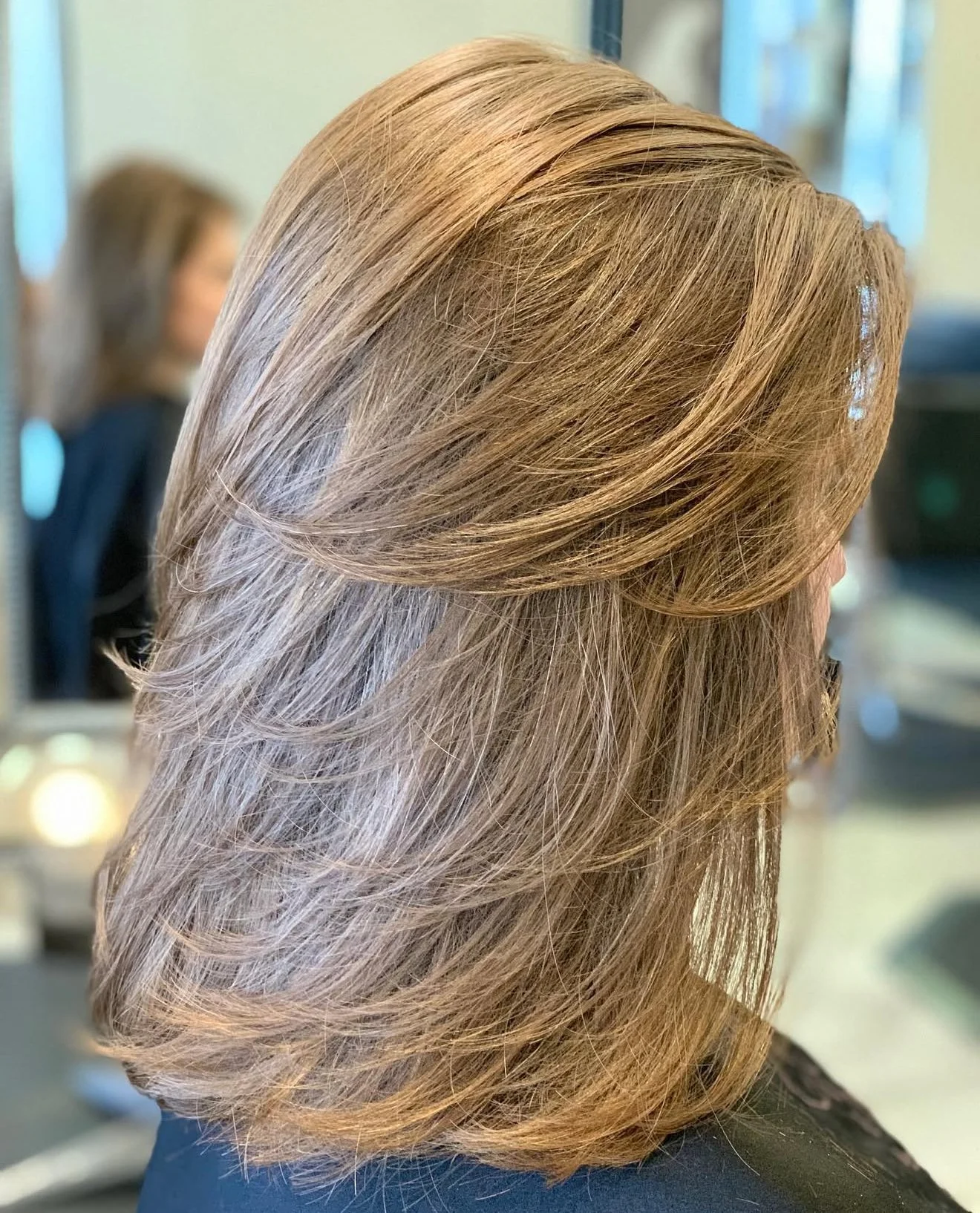 Dimensional blonde layered haircut designed to fall smoothly with natural movement