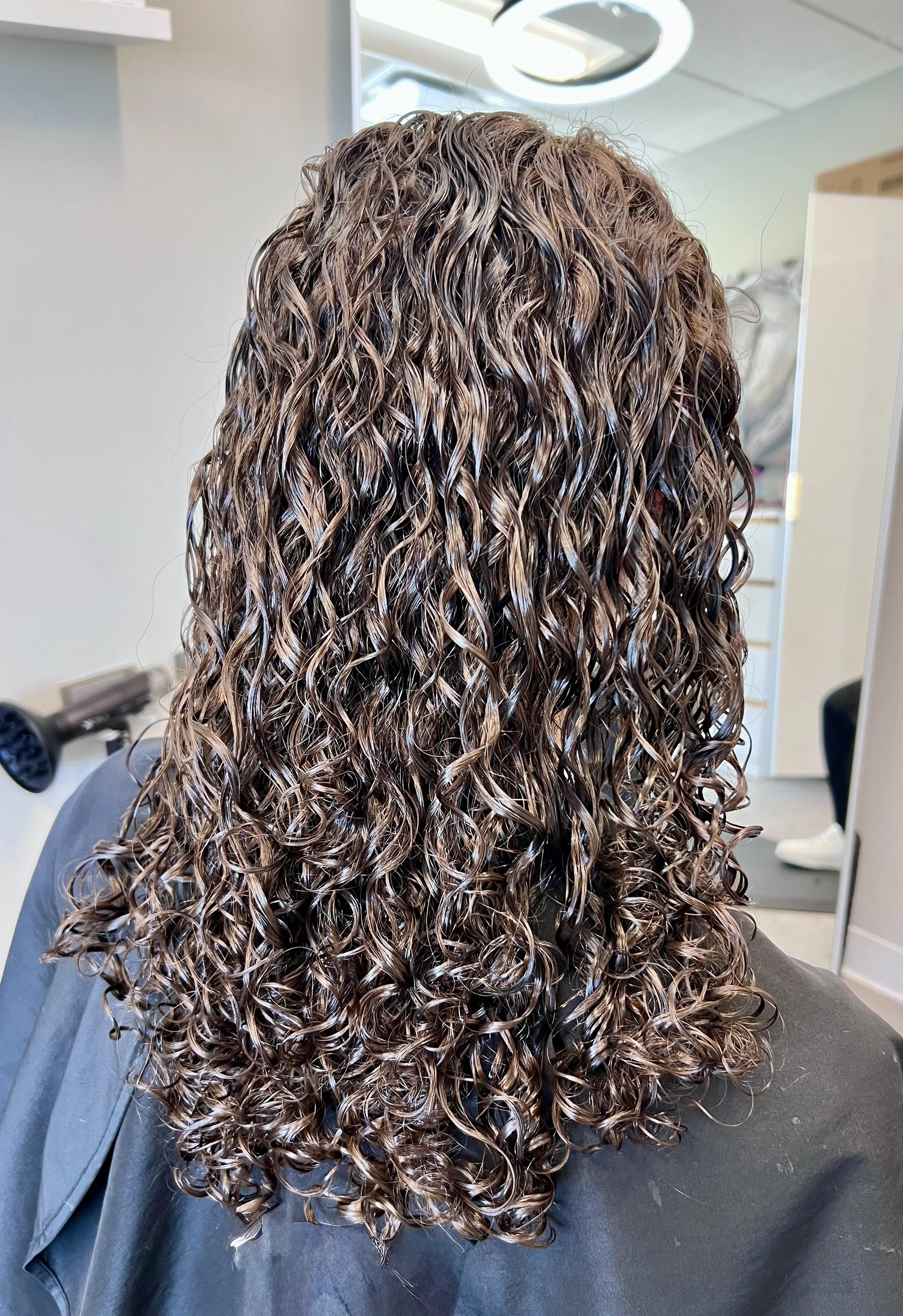 Curly haircut showing natural curl definition and balanced shape from the back