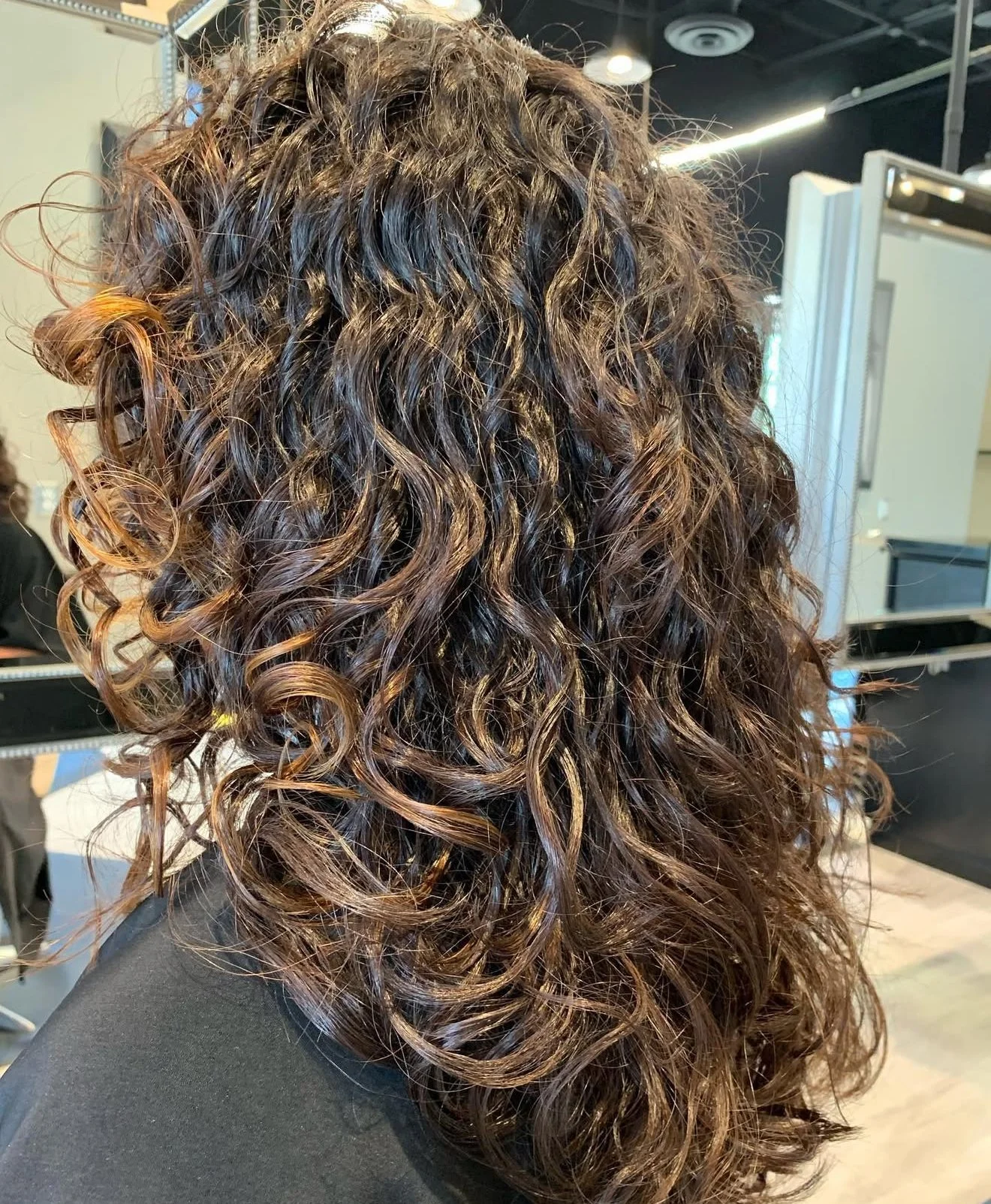 Curly haircut with defined layers and soft volume for medium-length curls