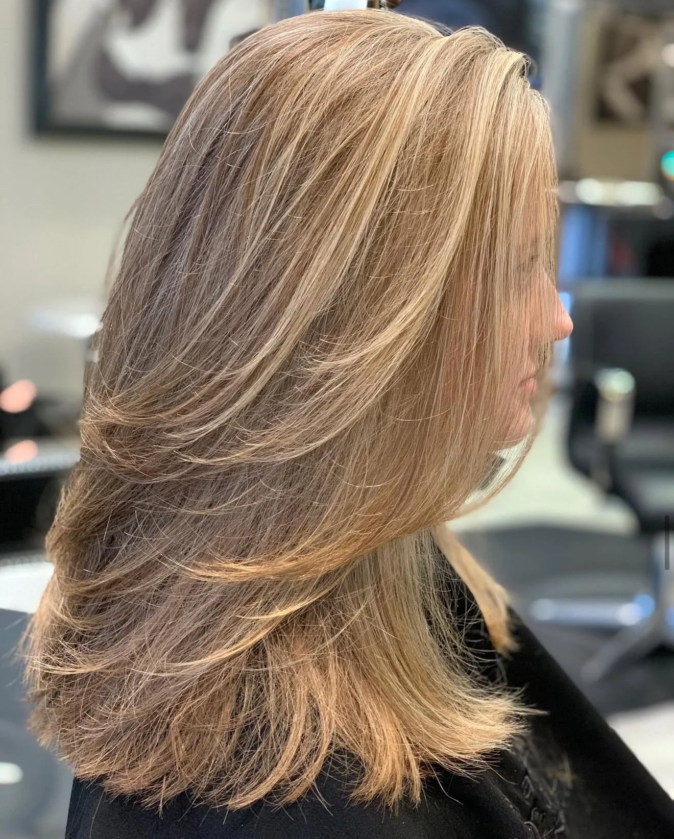 Blonde layered haircut in Frisco Texas with soft dimension, lightweight shape, and flowing ends