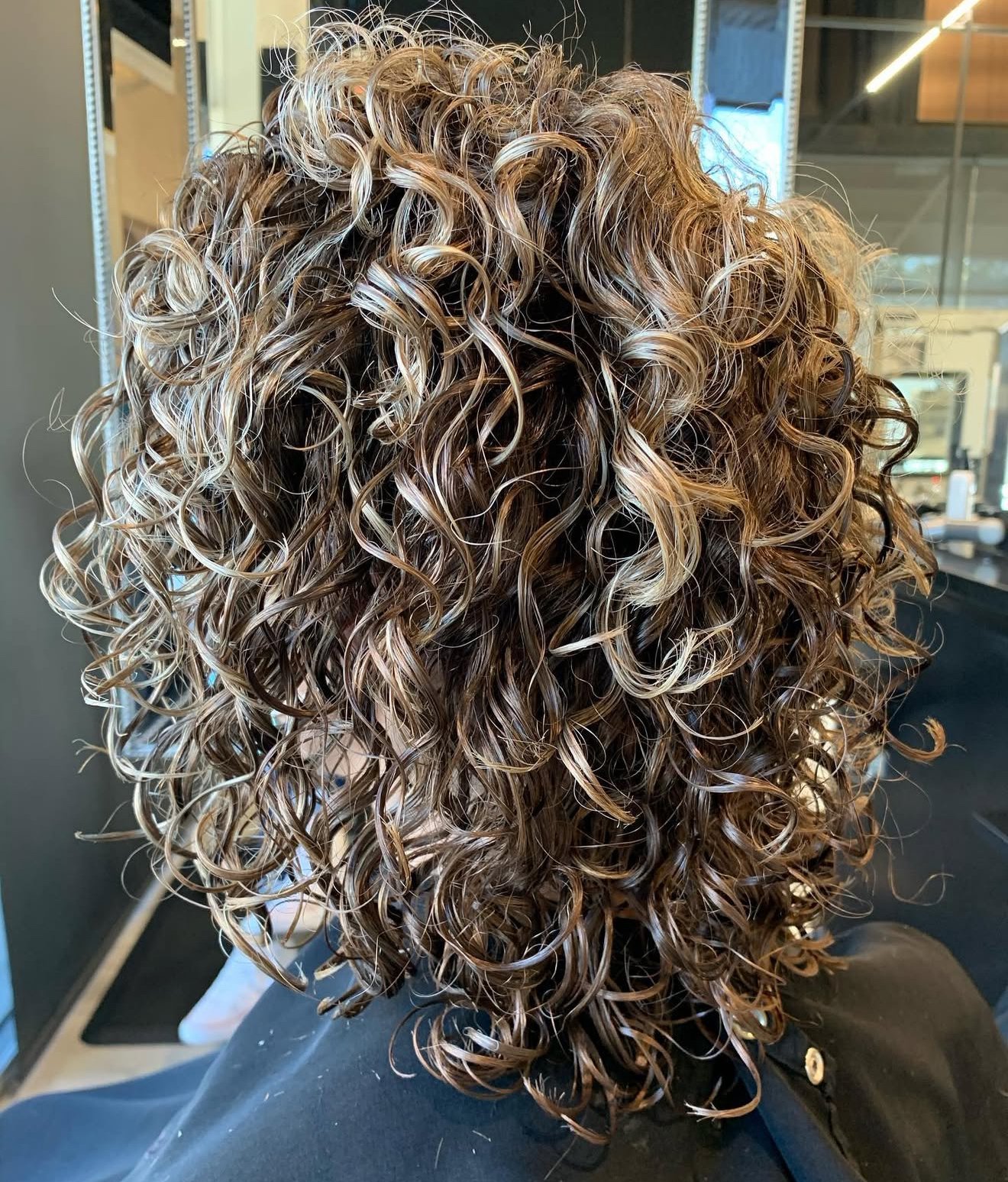 Curly haircut in Frisco, Texas with defined shape and soft volume