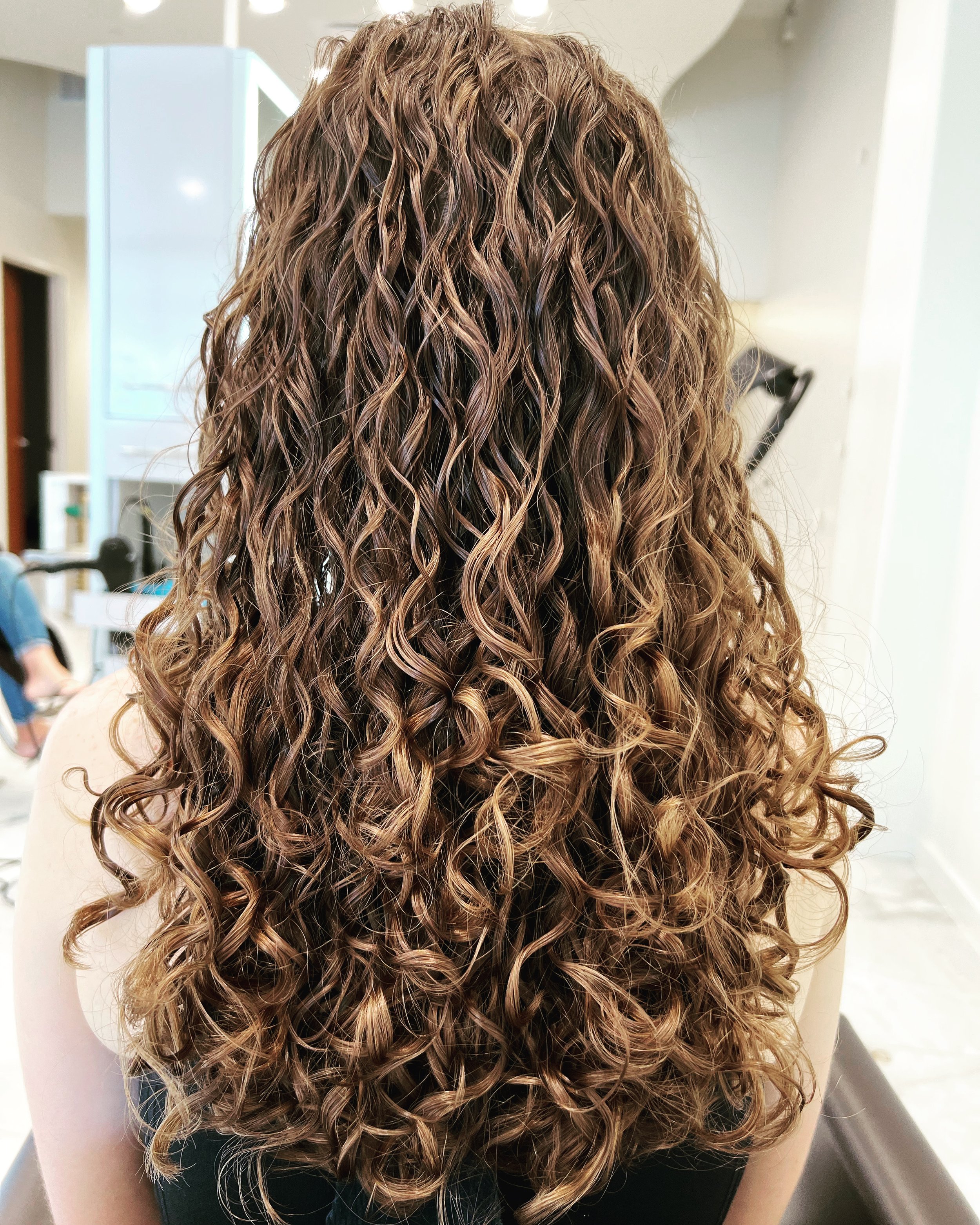 Long curly haircut with defined layers in Nichols Hills OKC
