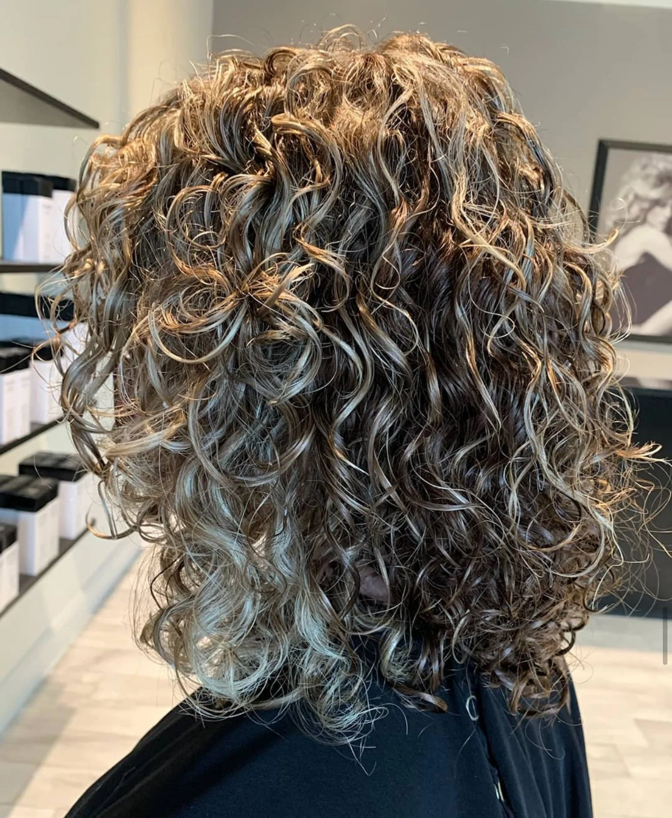 Curly cut with a rounded silhouette and controlled volume for thick curls