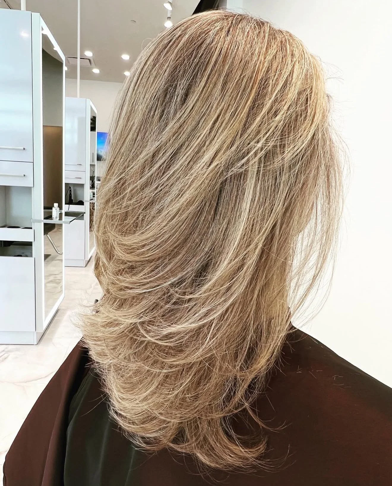 Dimensional blonde layered haircut with natural flow and balanced shape for fine to medium hair Frisco TX