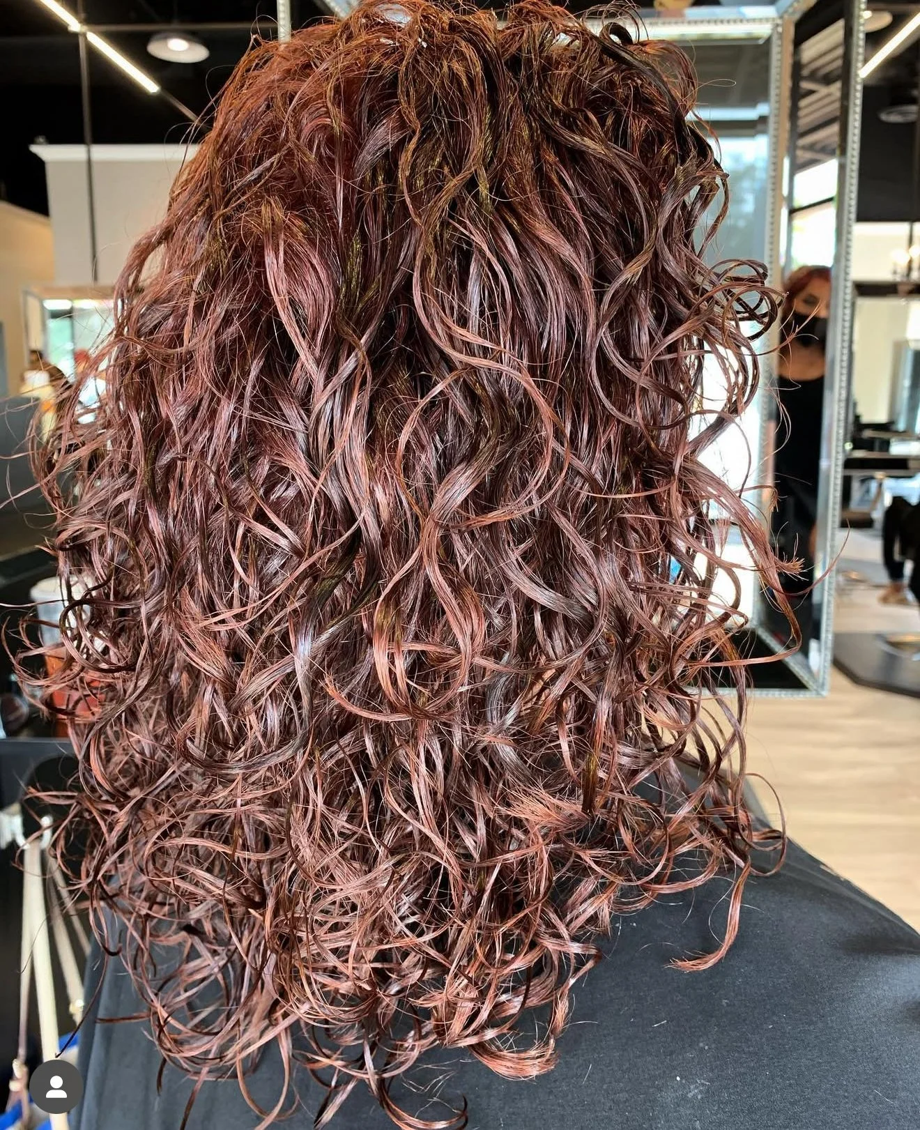 Curly haircut with dimensional color and structured shape for defined curls