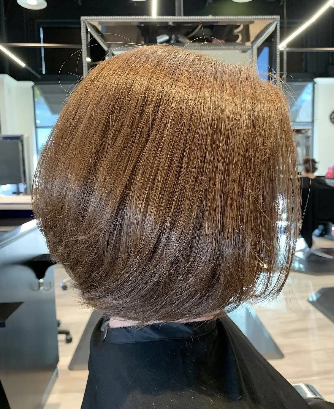 Rounded bob haircut with smooth styling and rich copper hair color