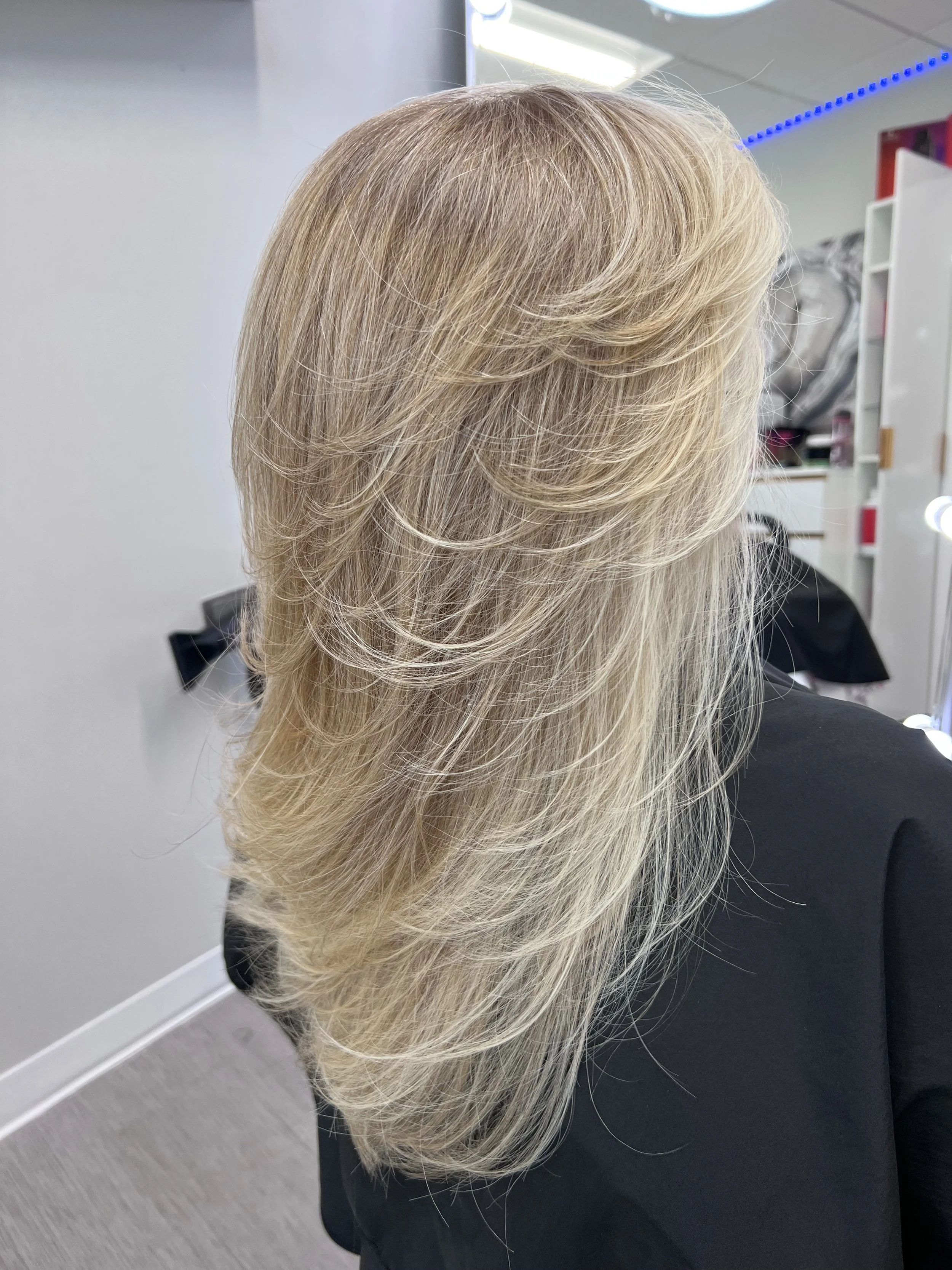 Precision layered blonde haircut with soft movement and controlled volume for fine hair in Frisco Texas
