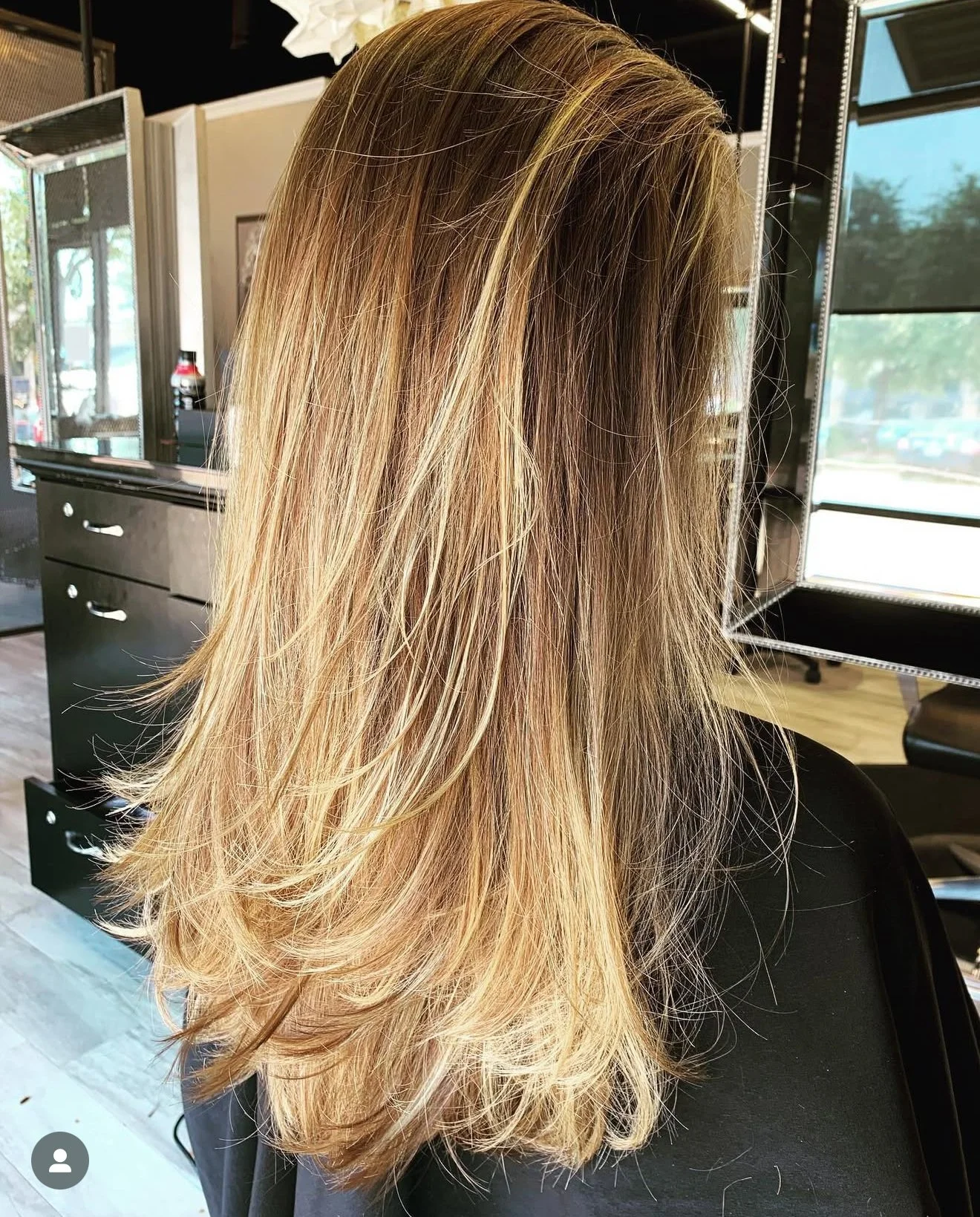 Luxury blonde layered haircut with cascading movement and natural face framing