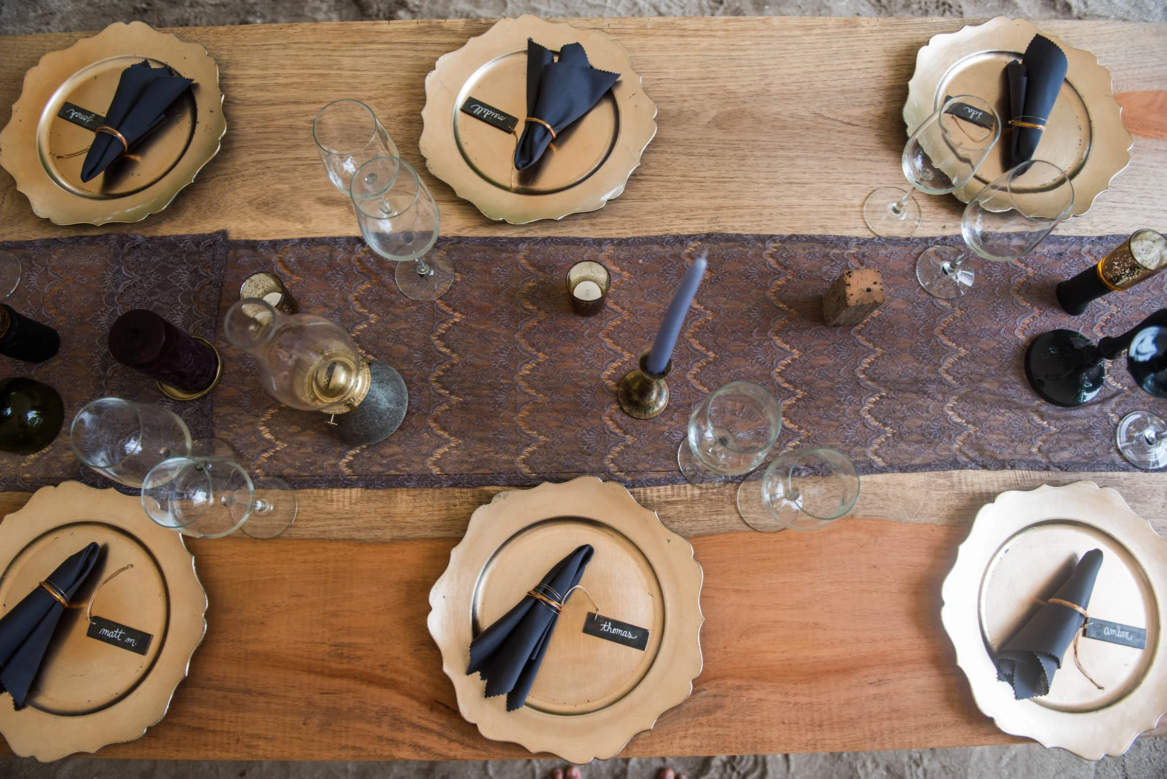 Gold plates and black napkins adorn table setting during reception for a Costa Rica beach wedding in Santa Teresa