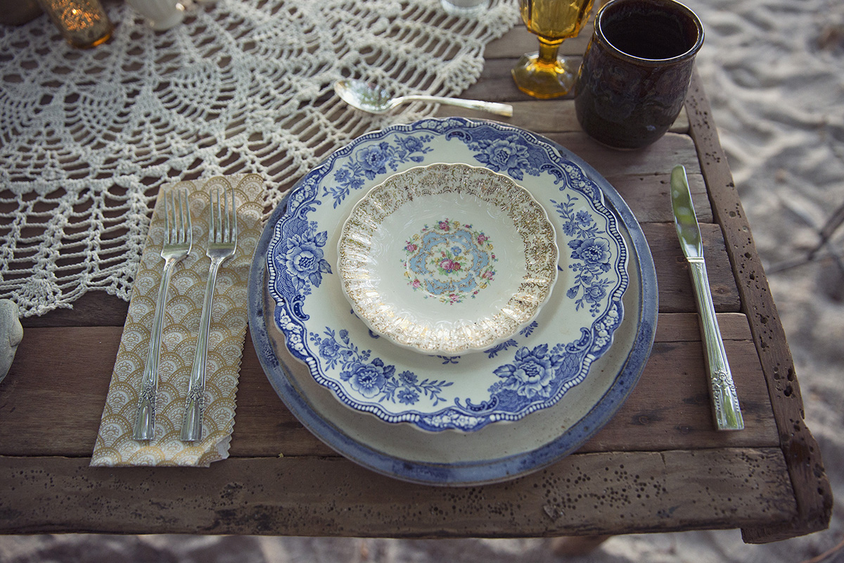 Lace and antique plates are table setting for rustic Costa Rica beach wedding in Santa Teresa